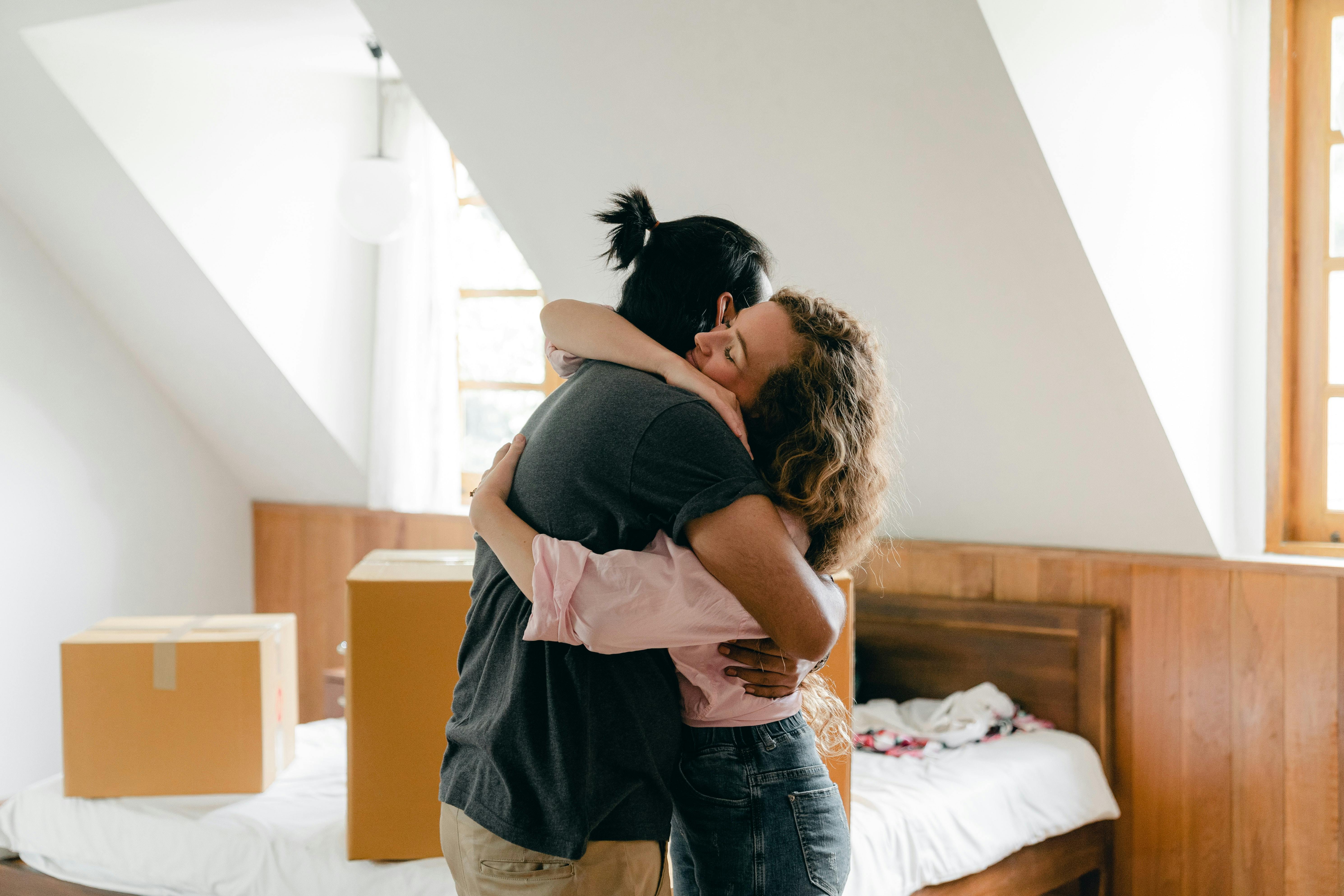 Man and woman embracing in home with moving boxes