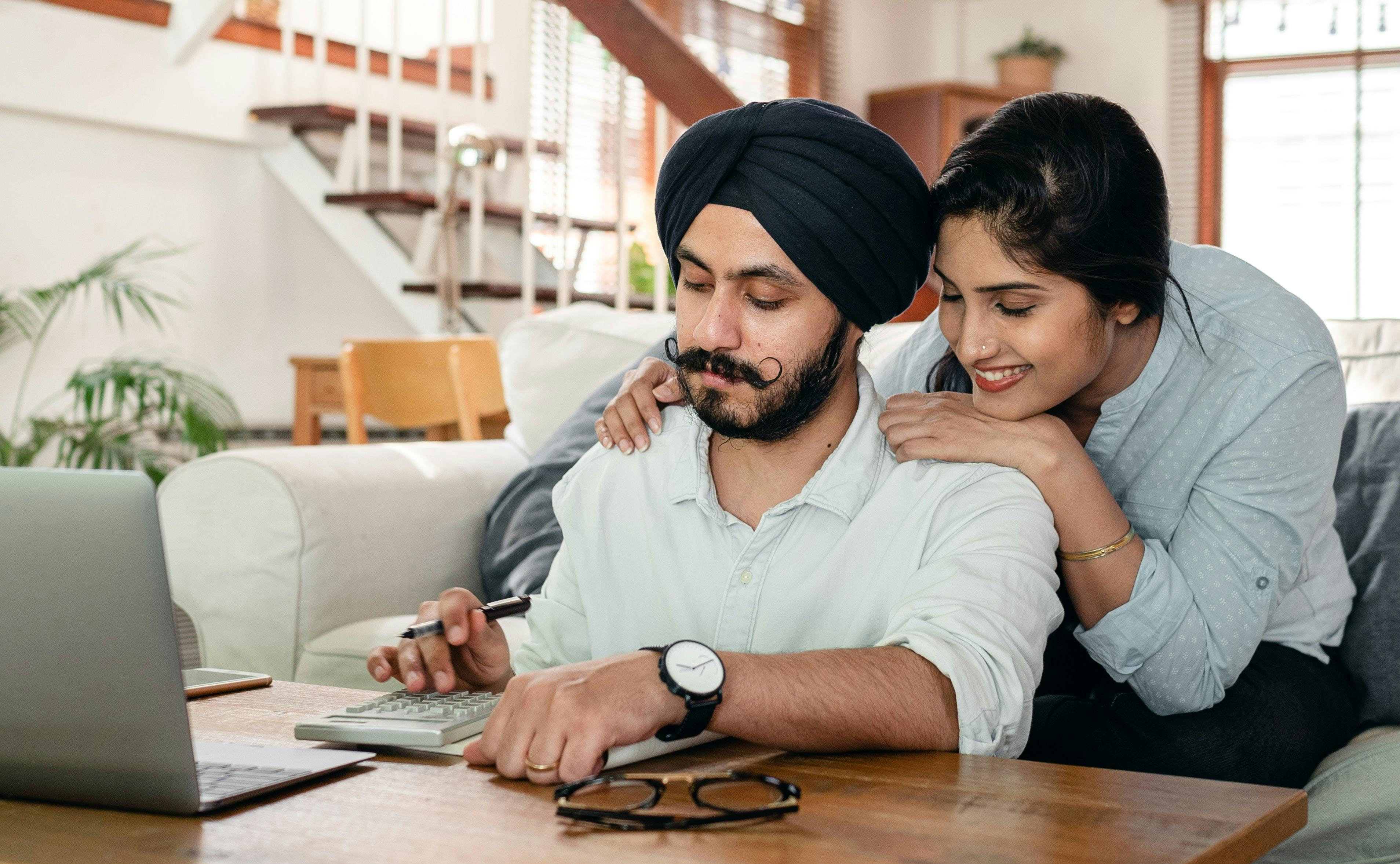 Couple at desk reviewing calculator