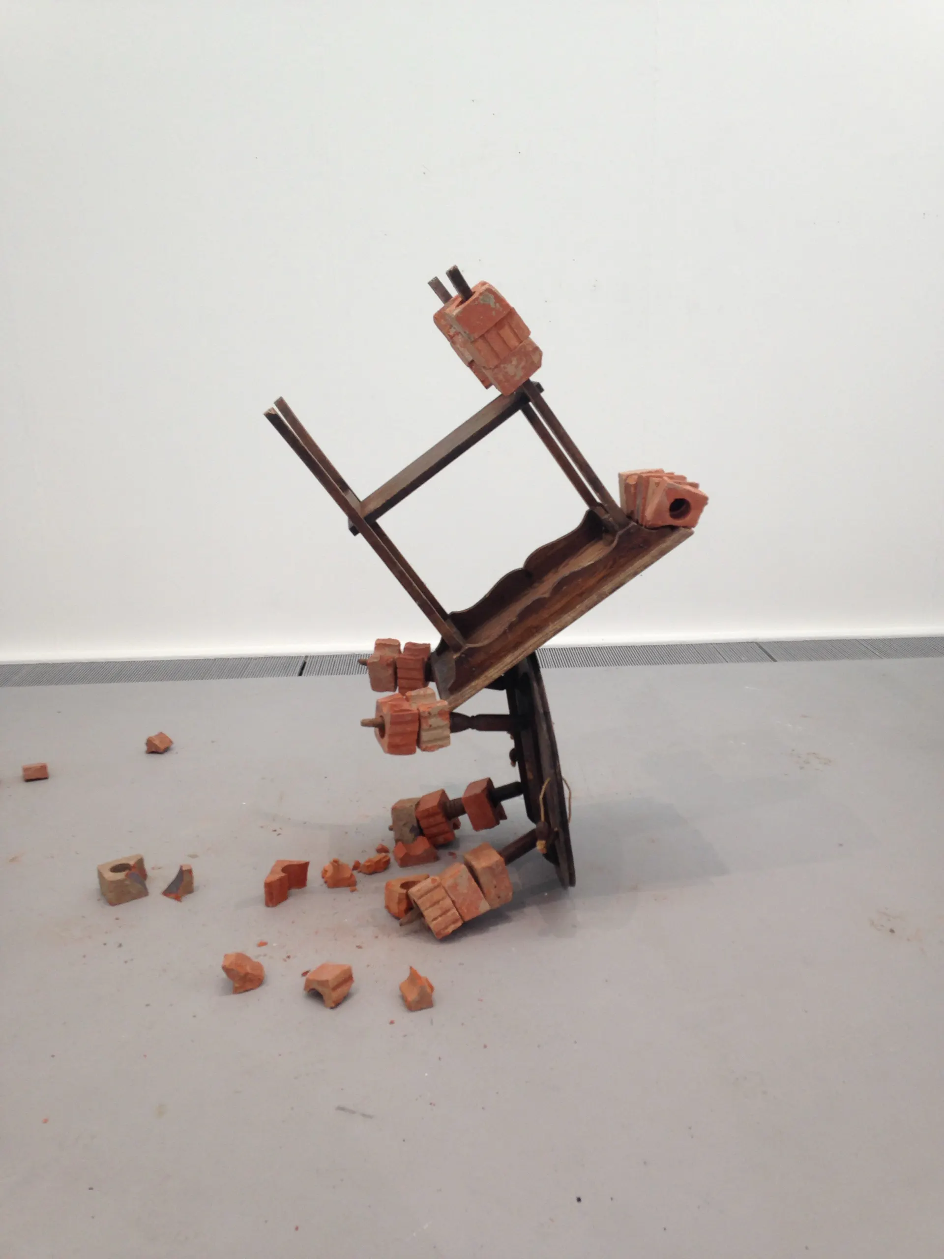A chair tipped and balanced on brick fragments