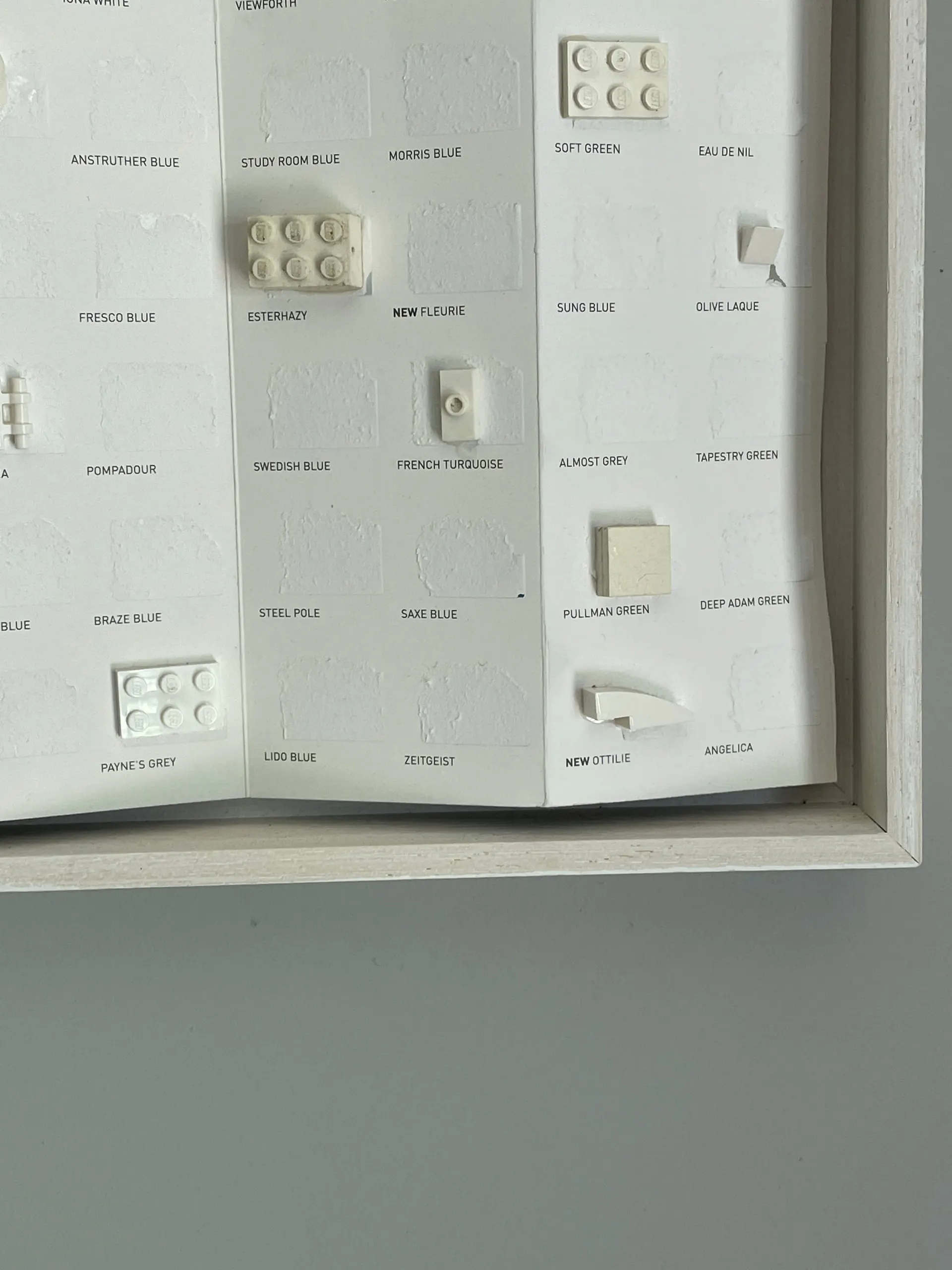 A paint chart with the colour peeled away, leaving embossed squares and the paint names