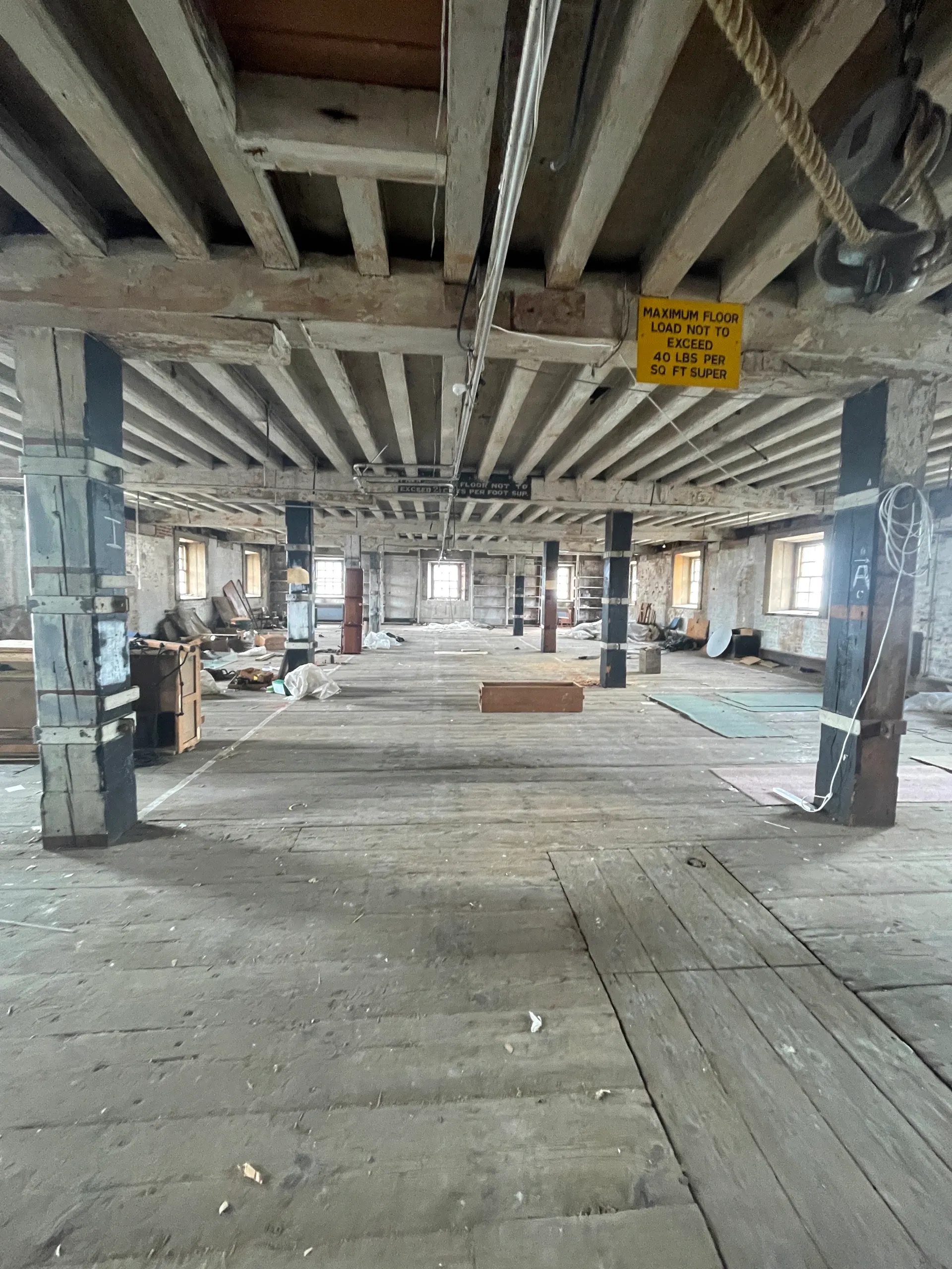 The empty upper floor of Storehouse 9, timber columns and beams receding into the space