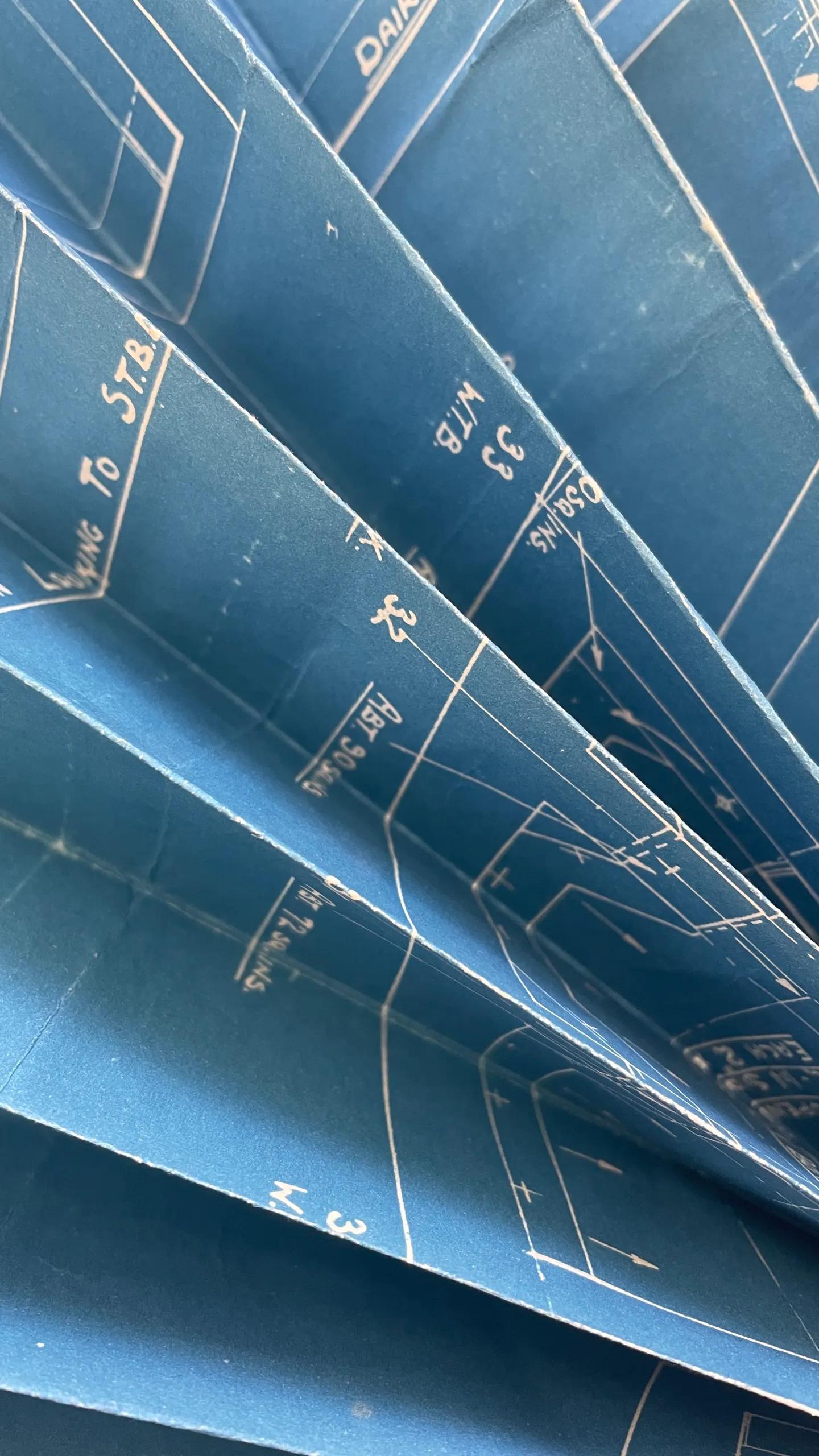 A fanned stack of 1940s blueprints