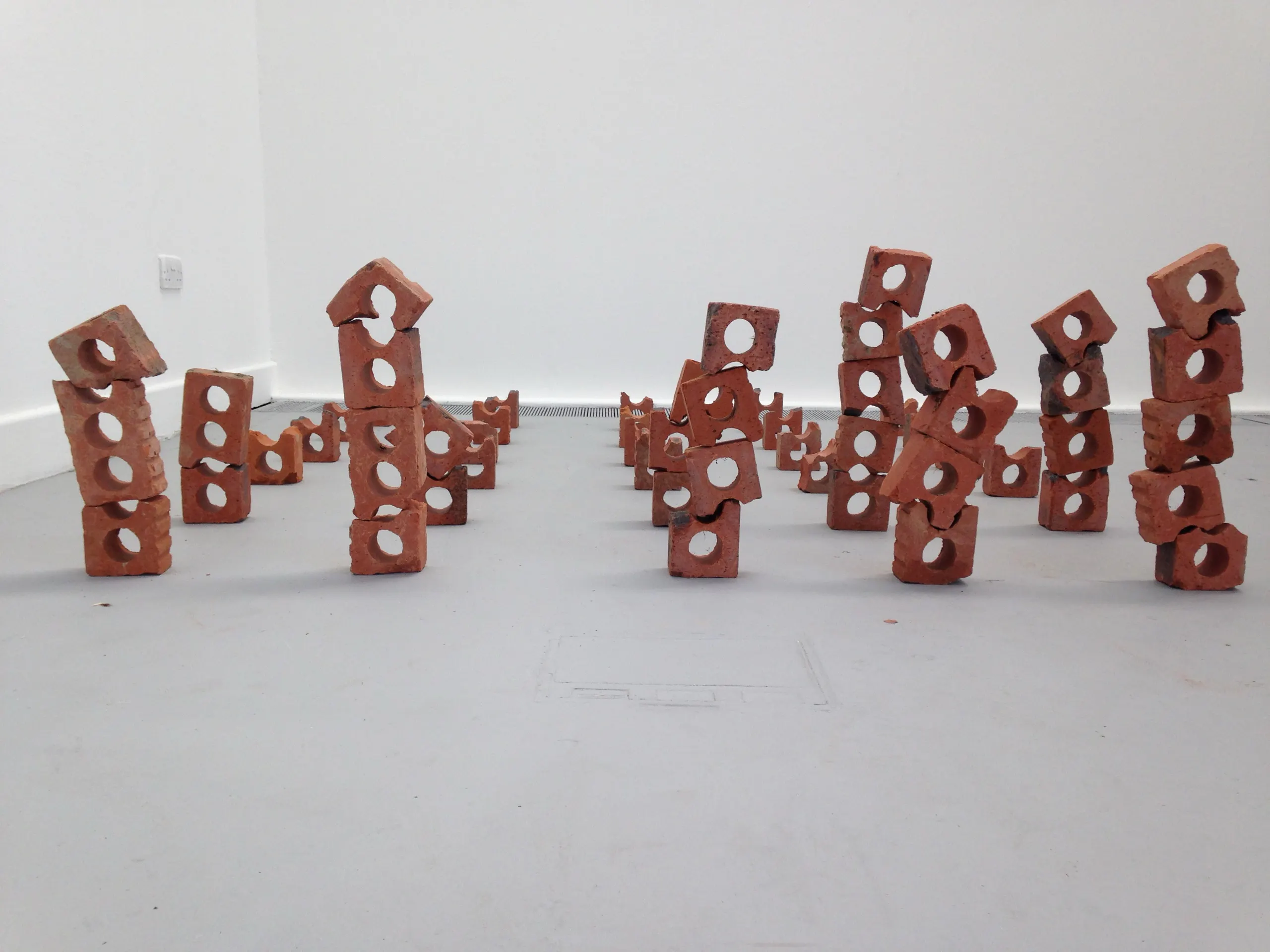 Small stacks of perforated brick arranged across the floor