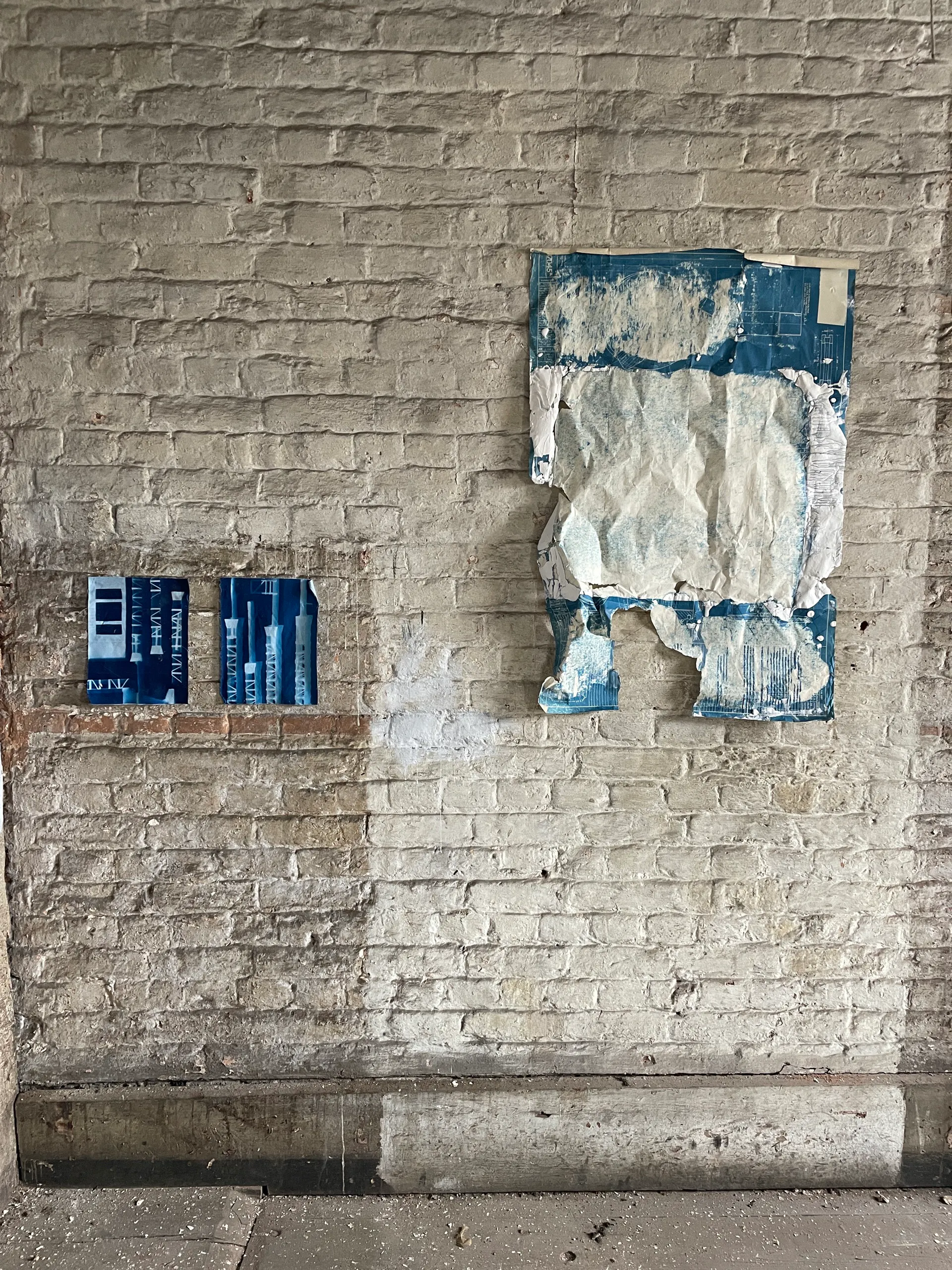 Two works installed on a brick wall