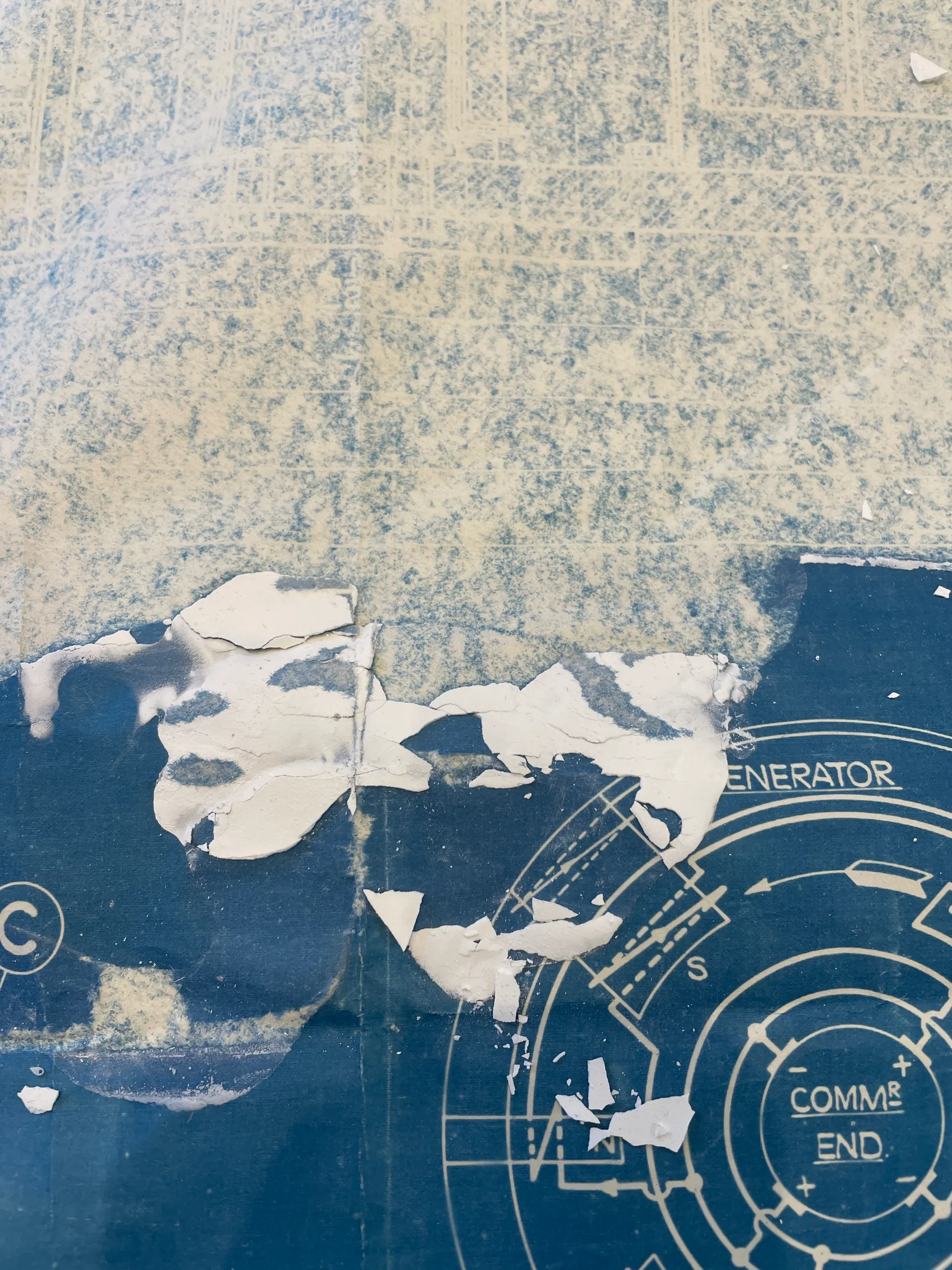 A blueprint with plaster peeling from its surface