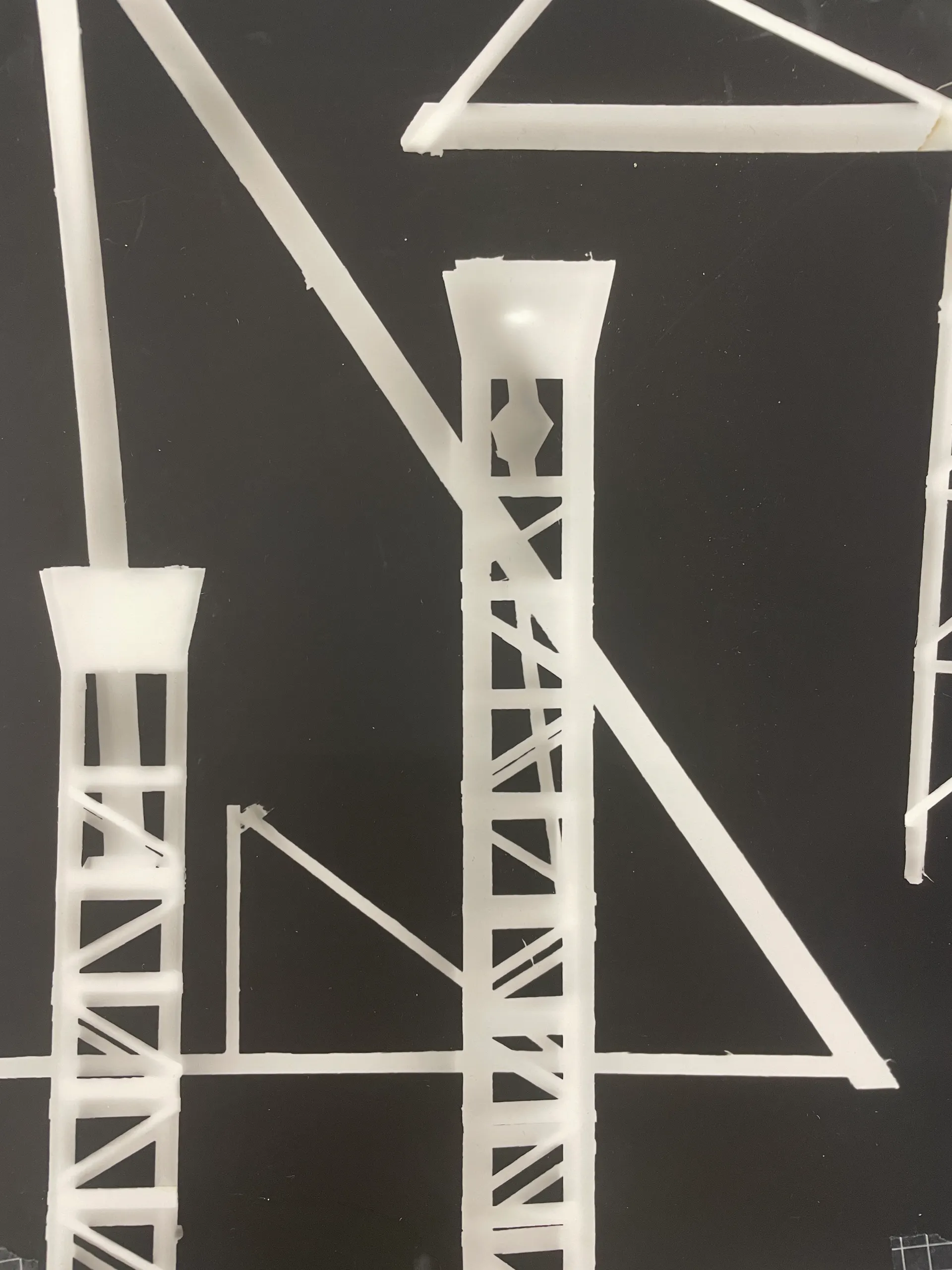 A photogram of architectural-model gantries, white on black