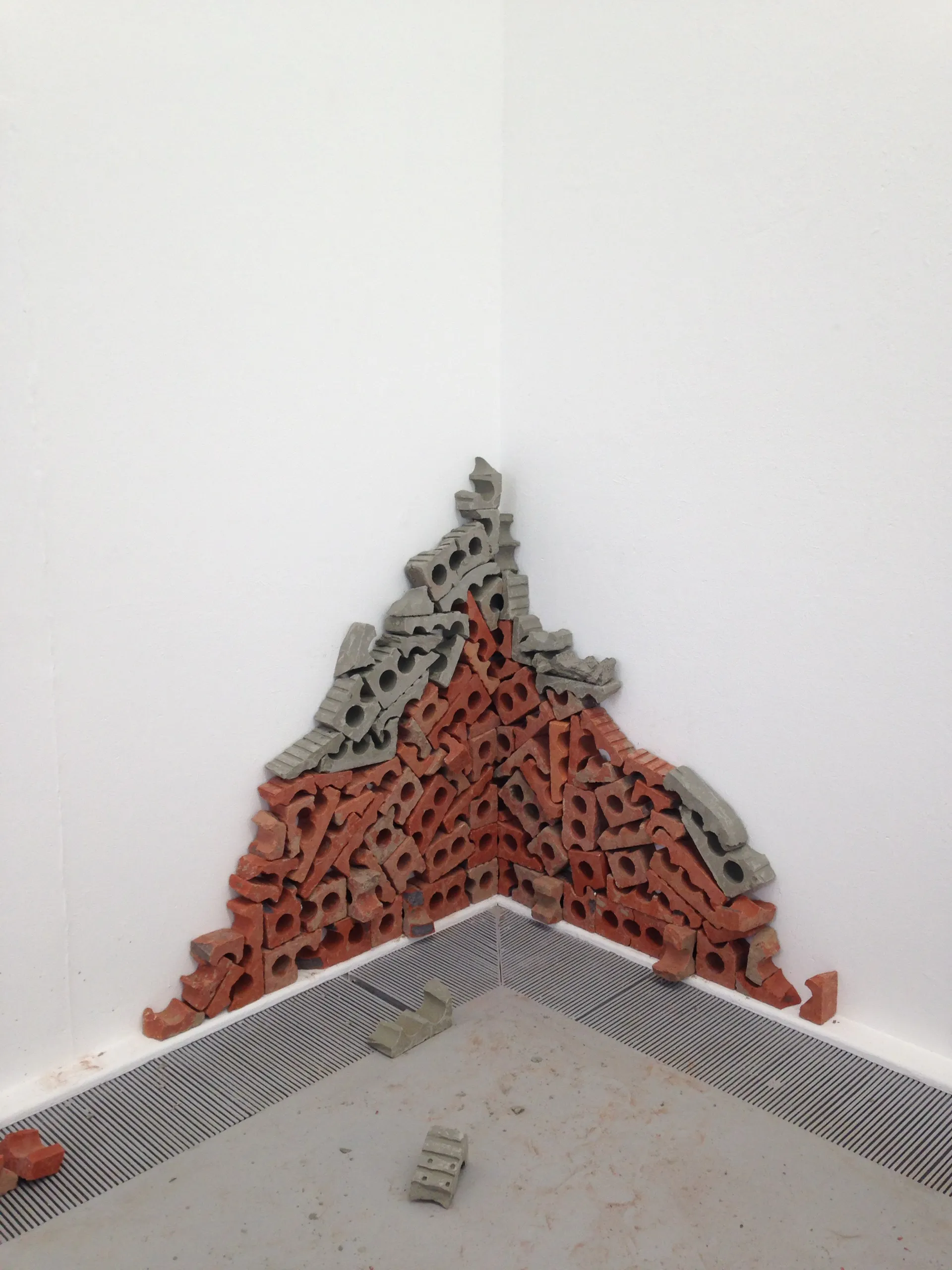 A triangular stack of fired and unfired brick built into a corner