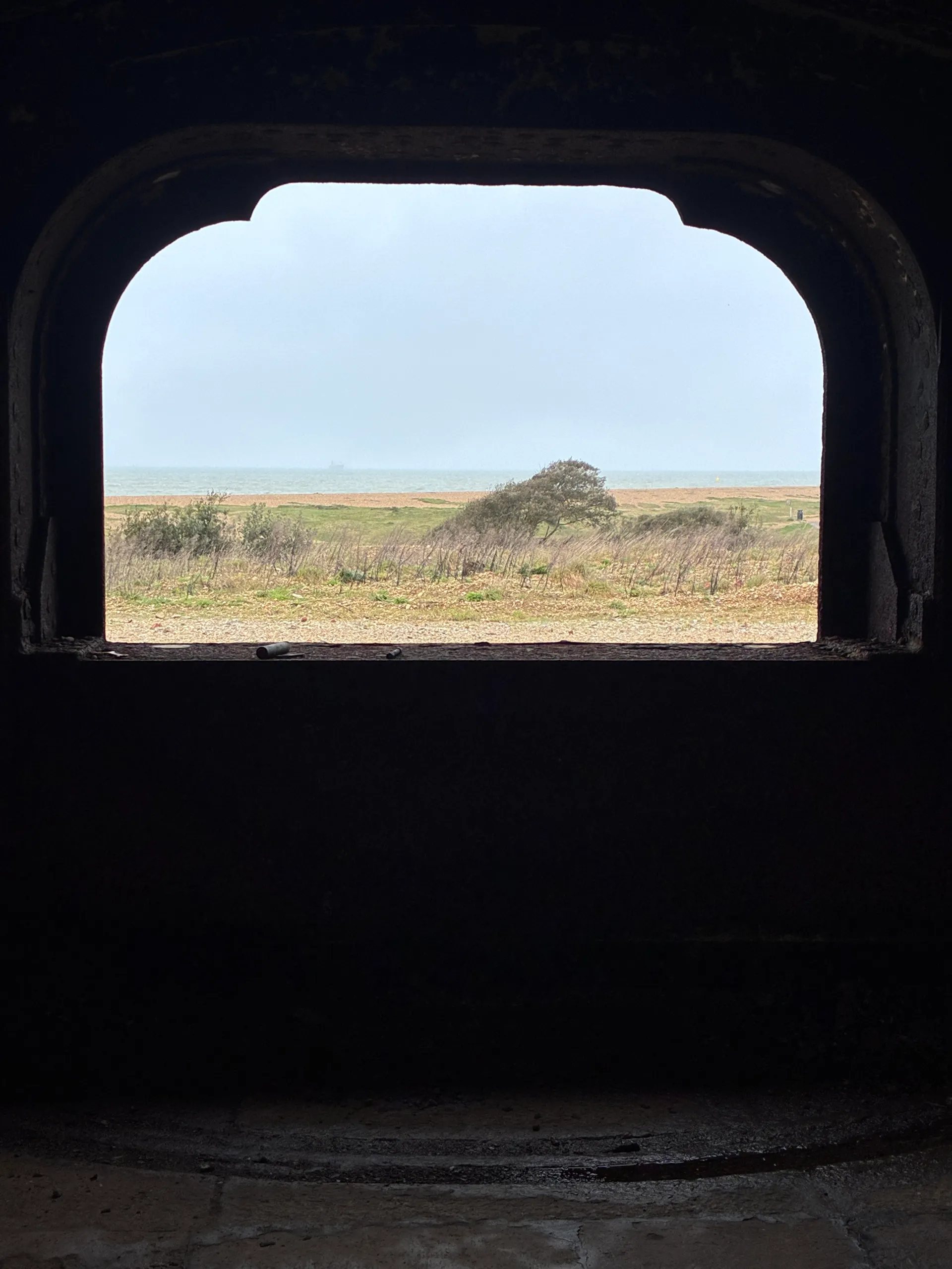 A gun embrasure framing the sea beyond the fort