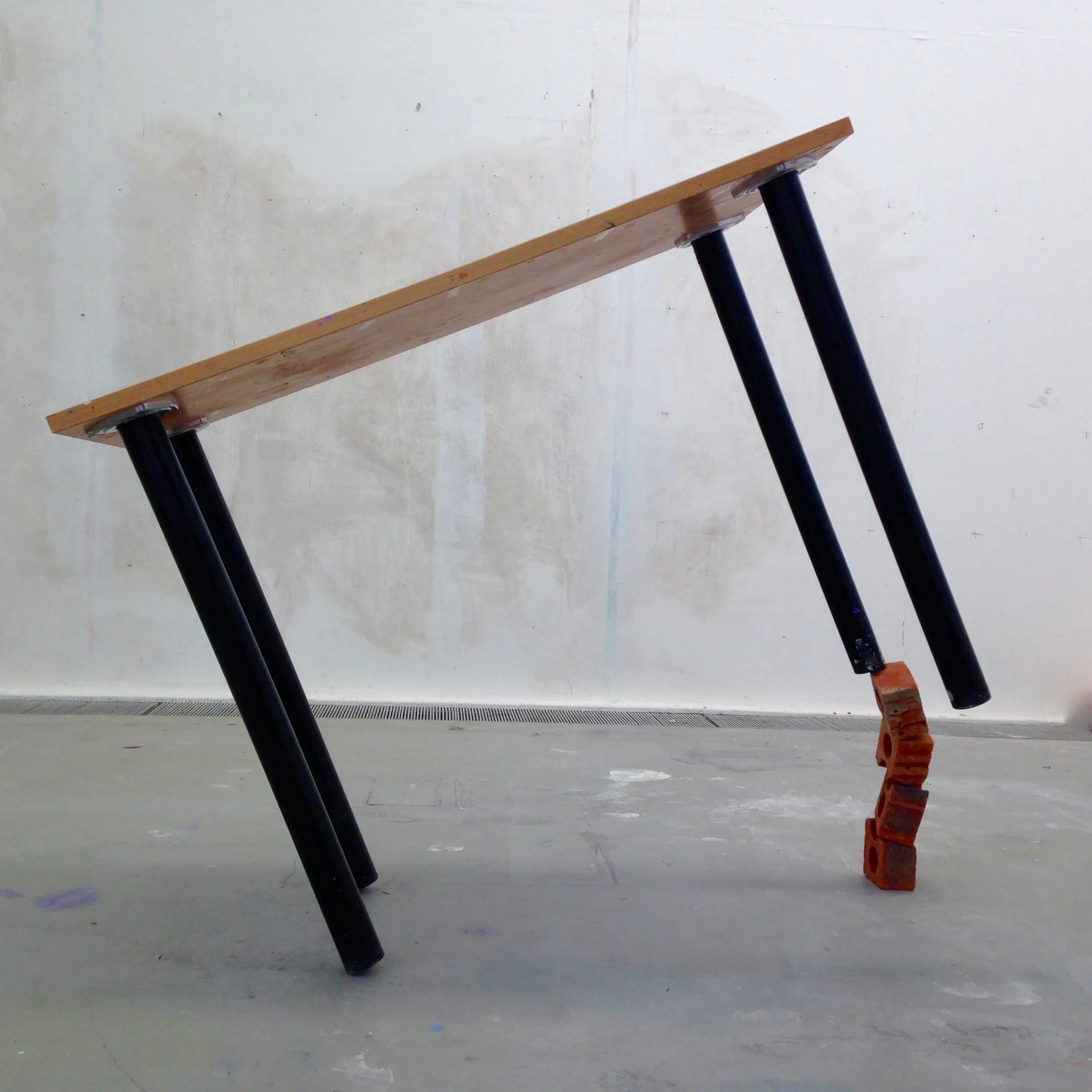 A table top balanced on a column of broken brick