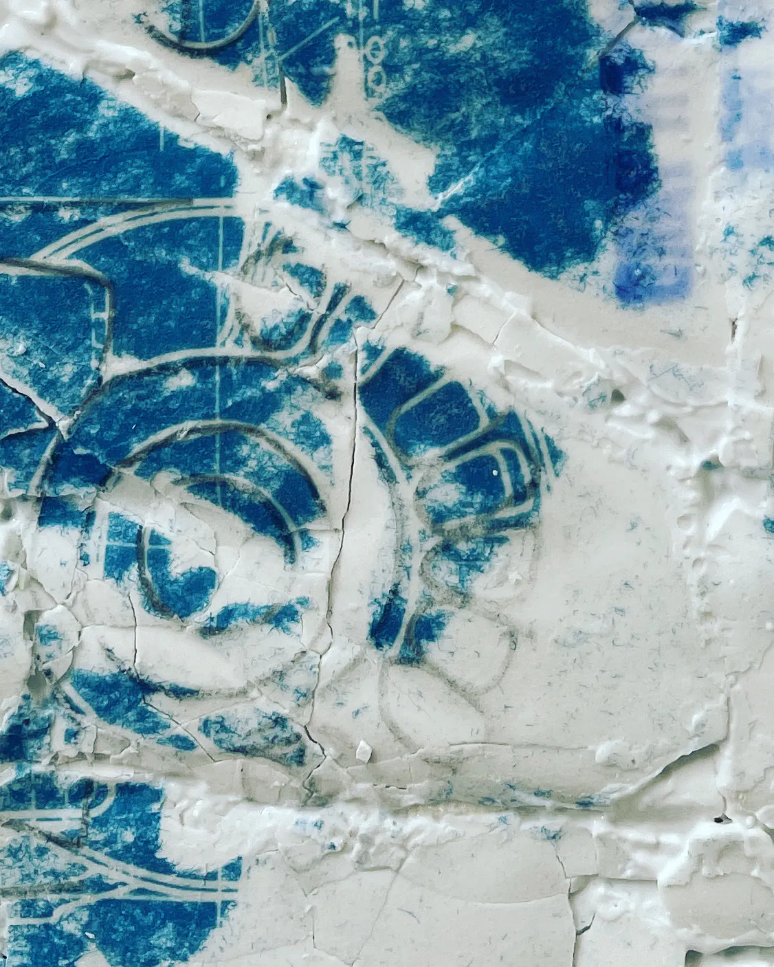 A cyanotype detail beneath cracked plaster