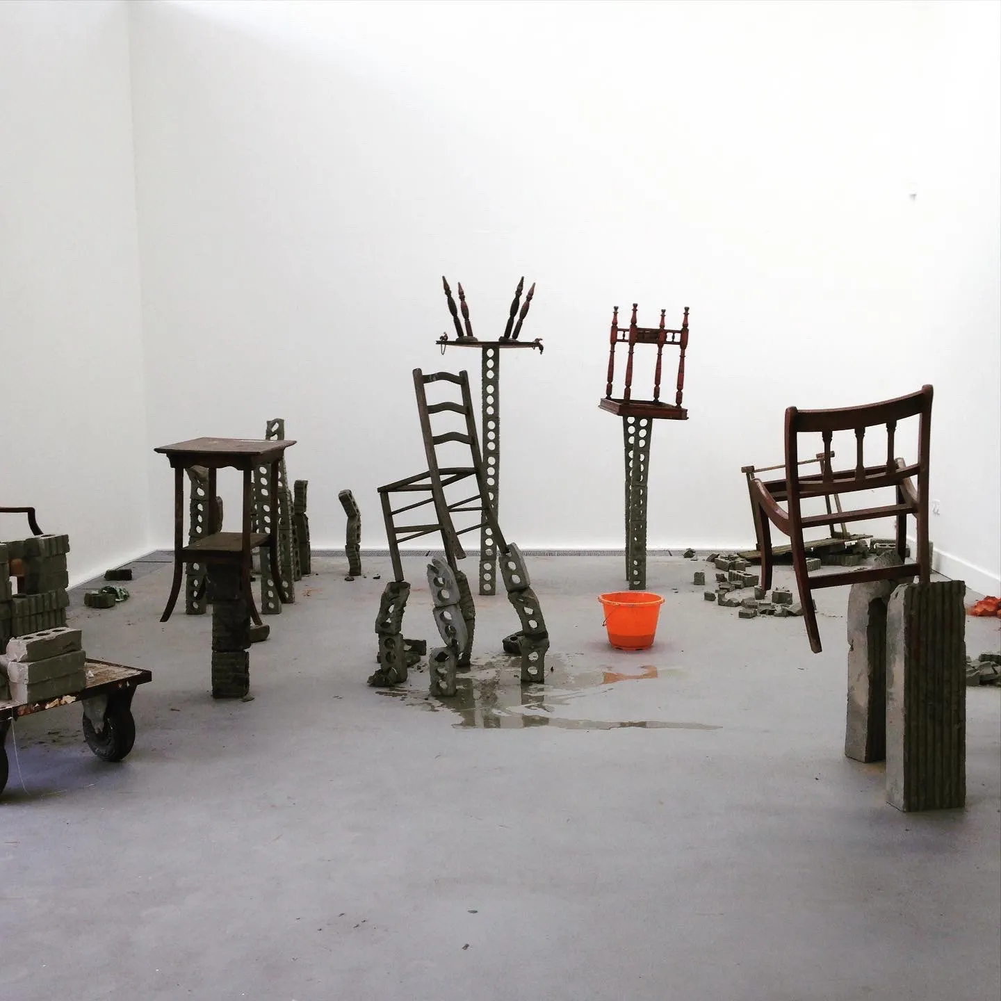 Chairs and tables raised on brick legs across the studio floor
