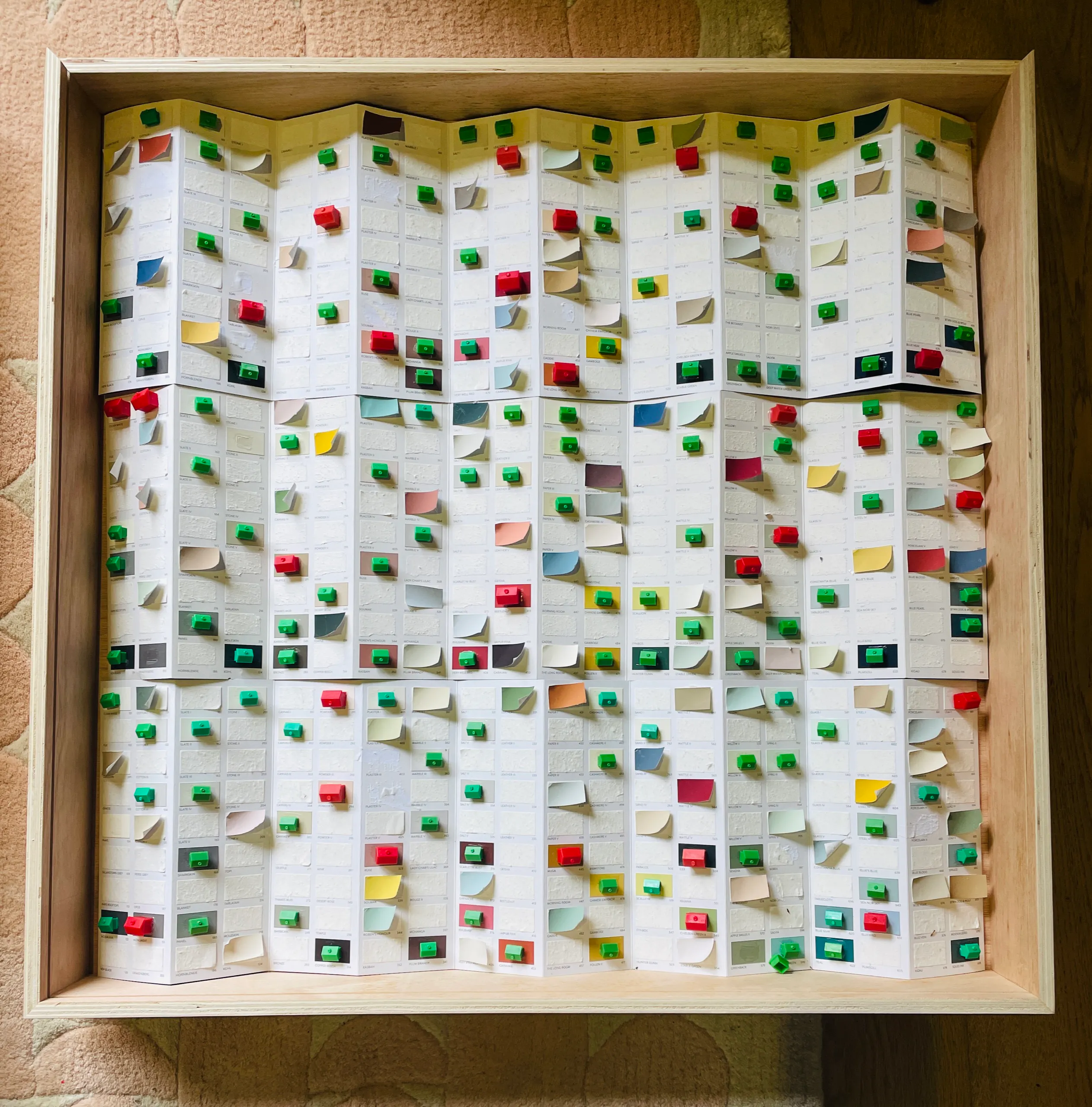 A framed concertina of paint charts with houses and hotels