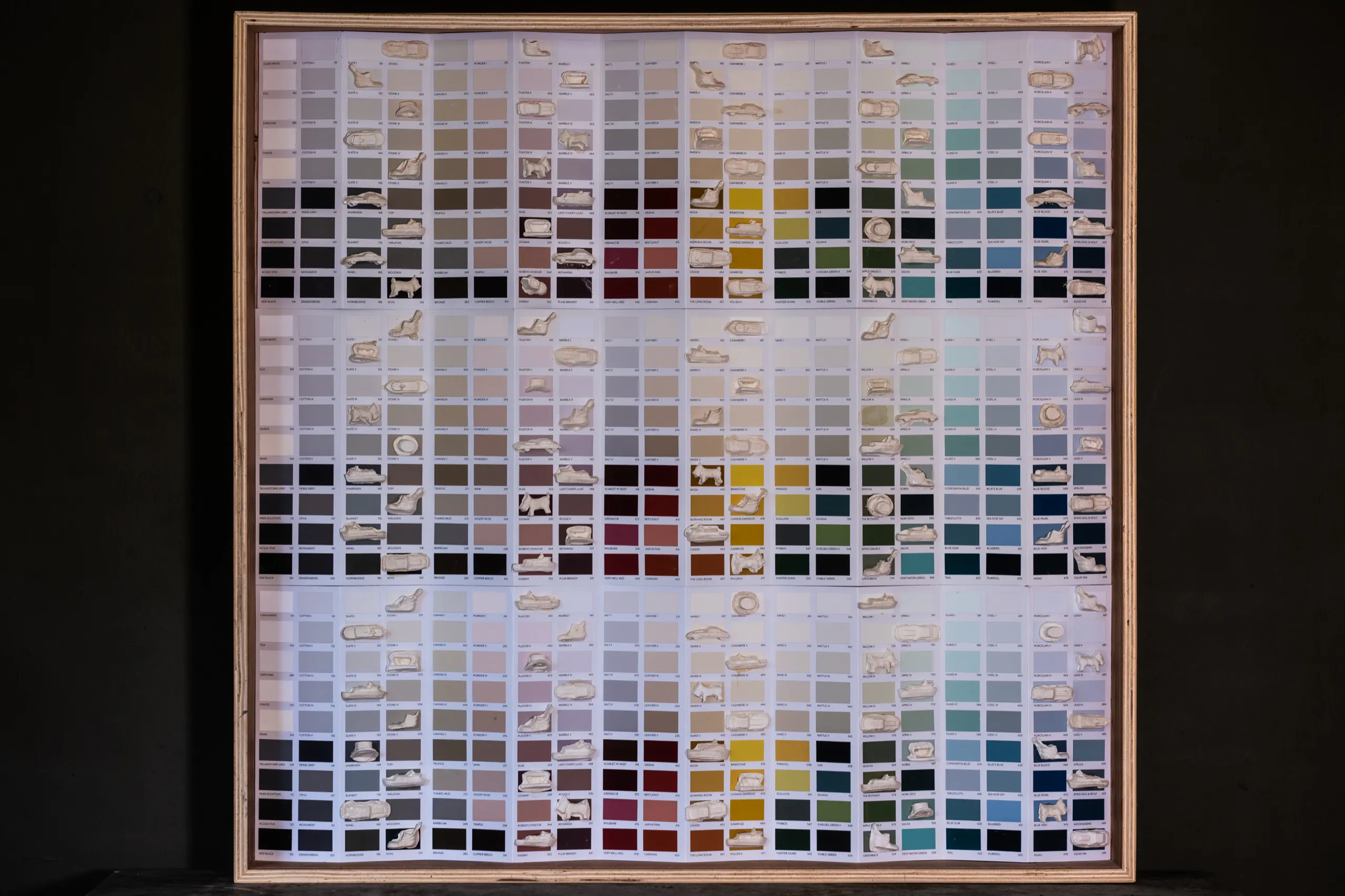 The framed grid of paint chips and cast Monopoly tokens, seen square on