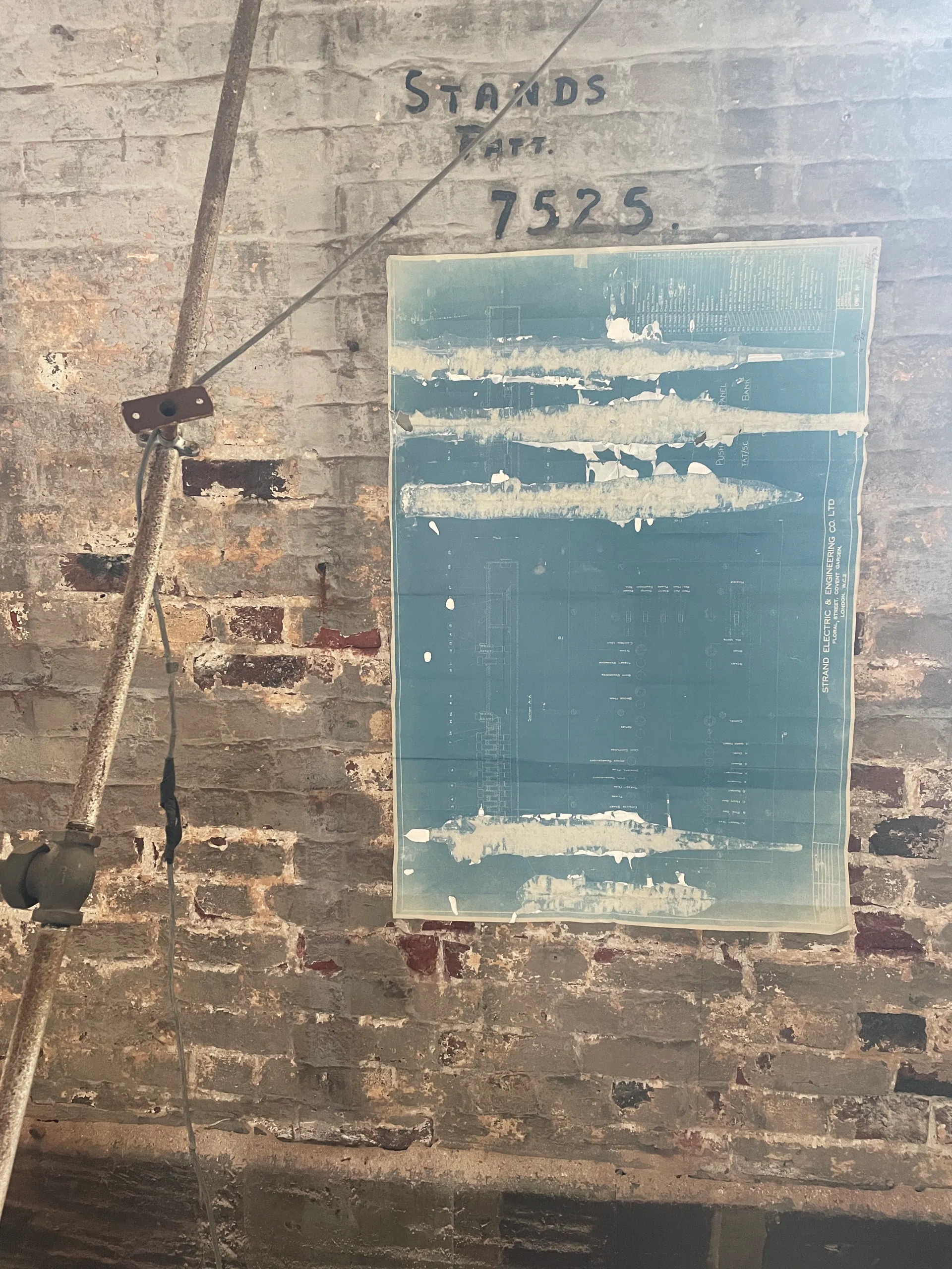A cyanotype-and-plaster work on a brick wall