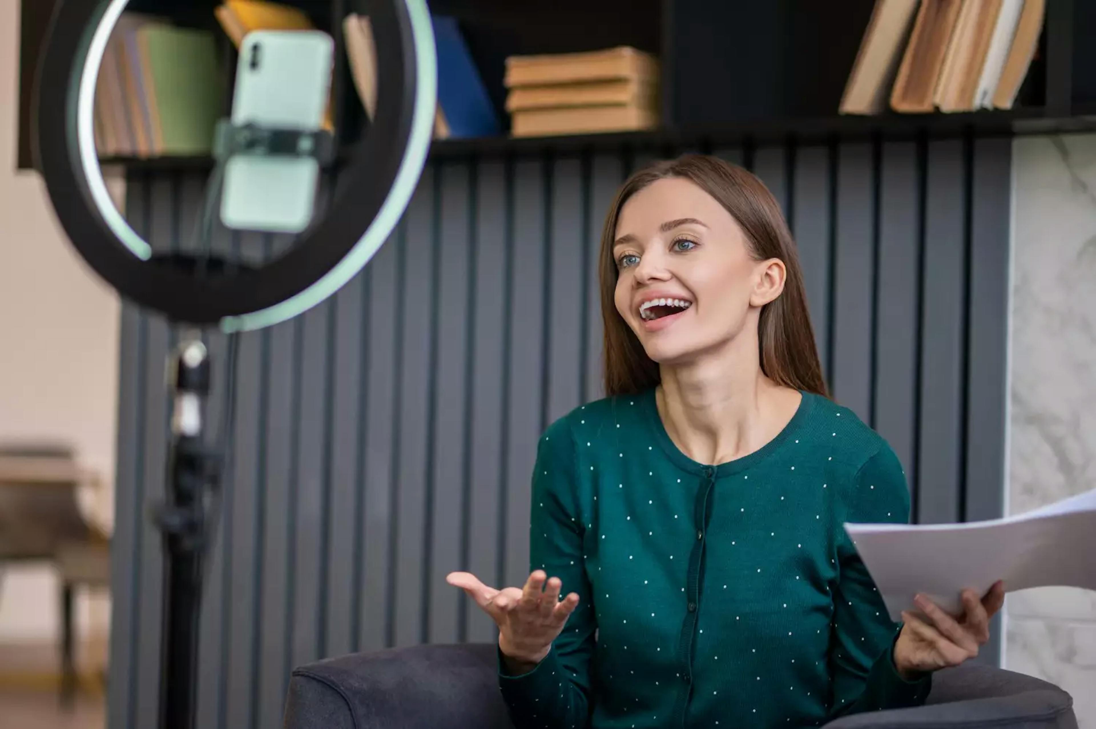 a woman filming herself with a smartphone for a corporate video