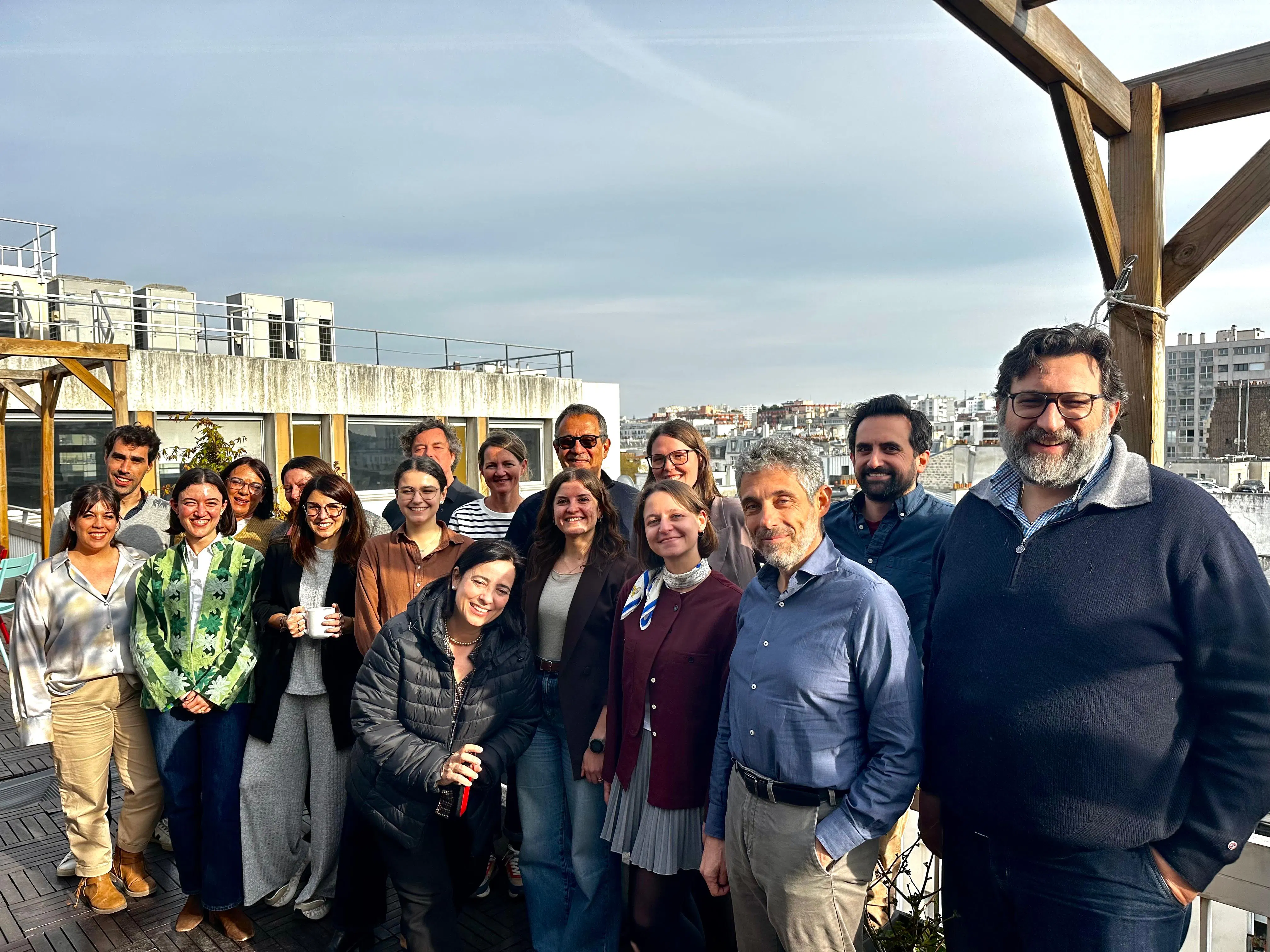 Un vingtaine de membres du projet Digiclass posent pour une photo de groupe sur une terrasse dans les bureaux de Pix.