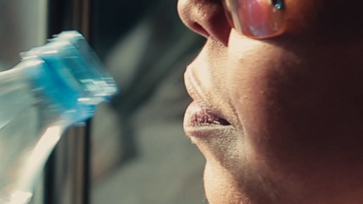 Closeup of woman drinking bottle of water 