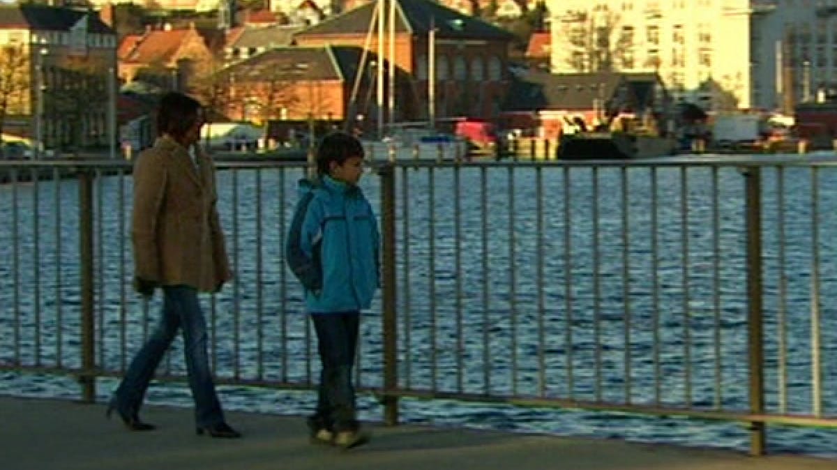 An adult and child walking up the waterfront 