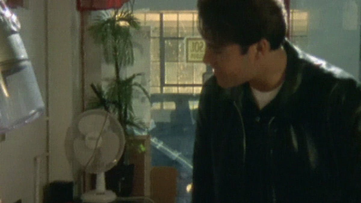 Closeup of man in a room with plants and a table fan