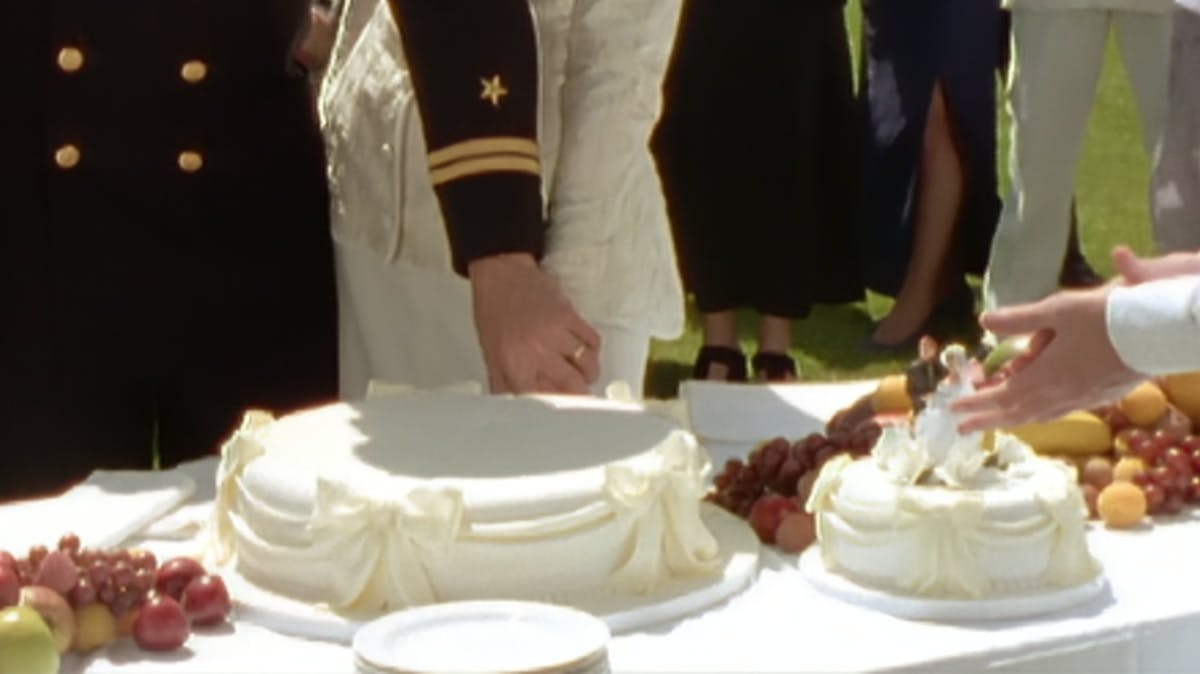 closeup of hands reaching for a slice of cake
