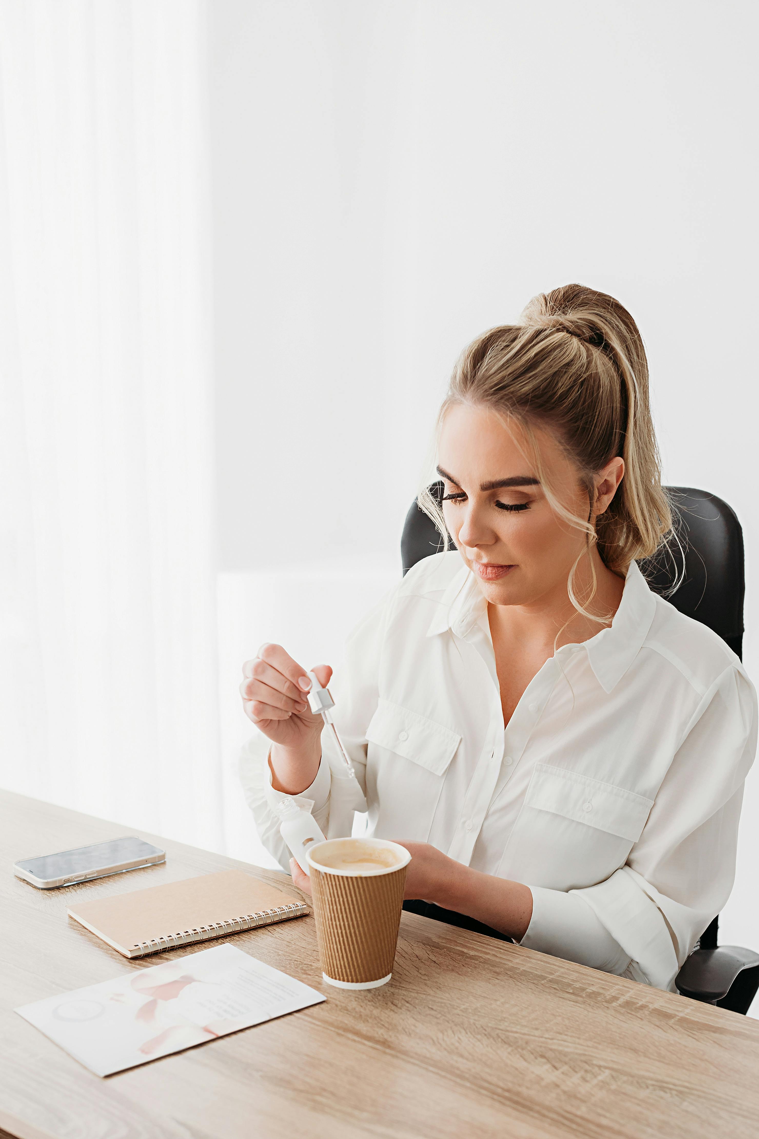 Woman adding vitamin to coffee