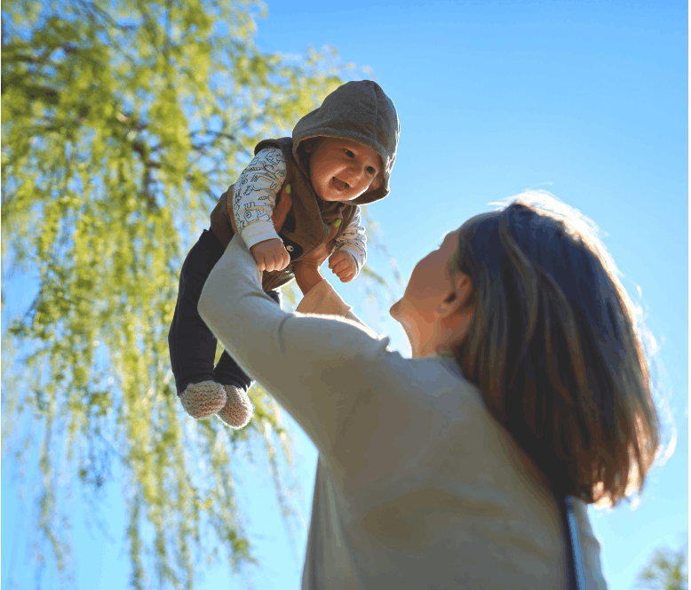 woman holding baby in the air