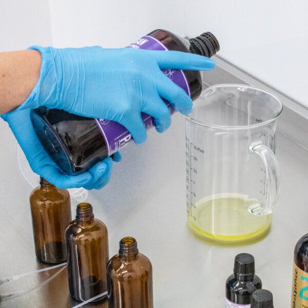 a person pouring chemicals into a beaker