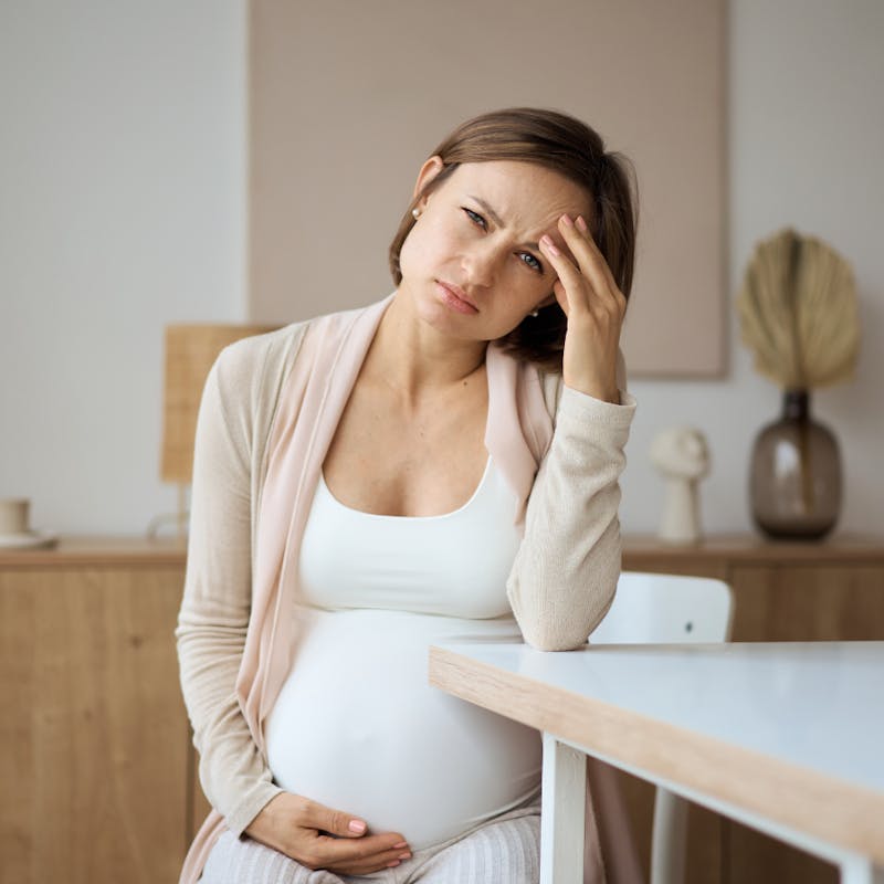 pregnant woman holding her head