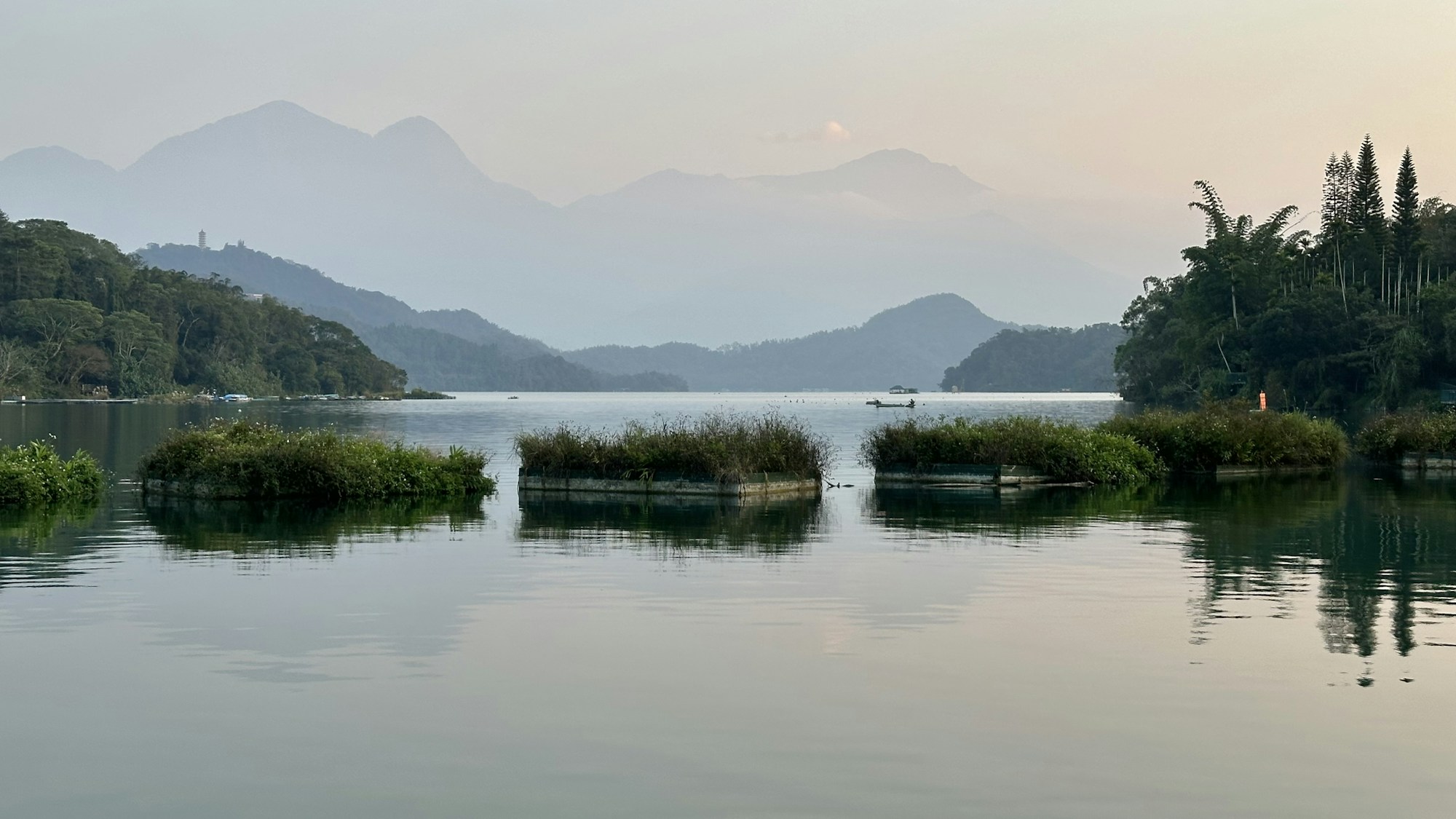 A body of water surrounded by trees and mountains