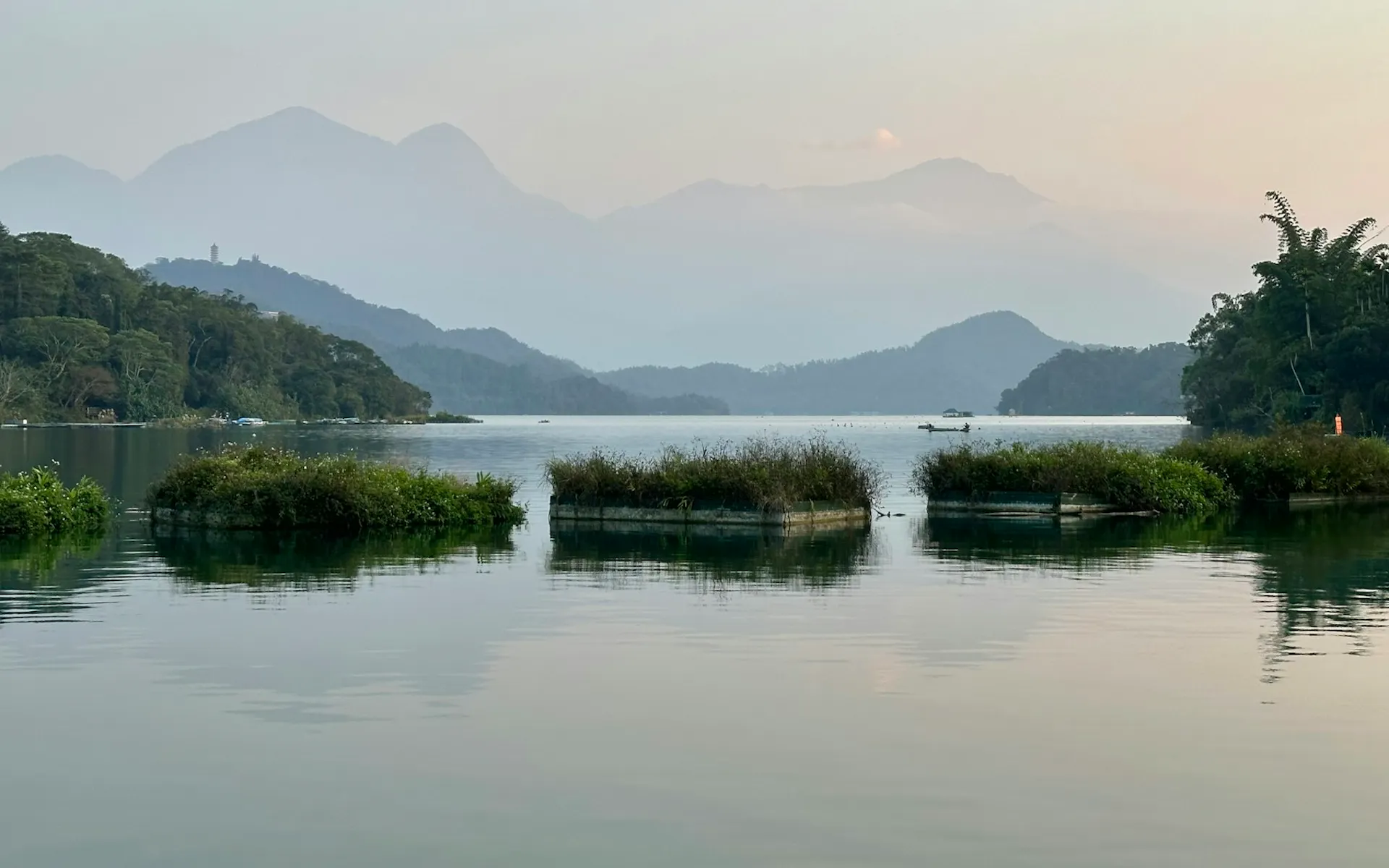 A body of water surrounded by trees and mountains