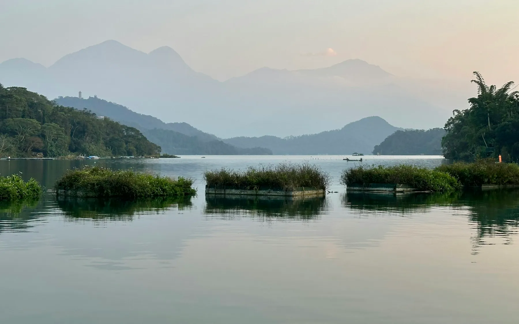 A body of water surrounded by trees and mountains