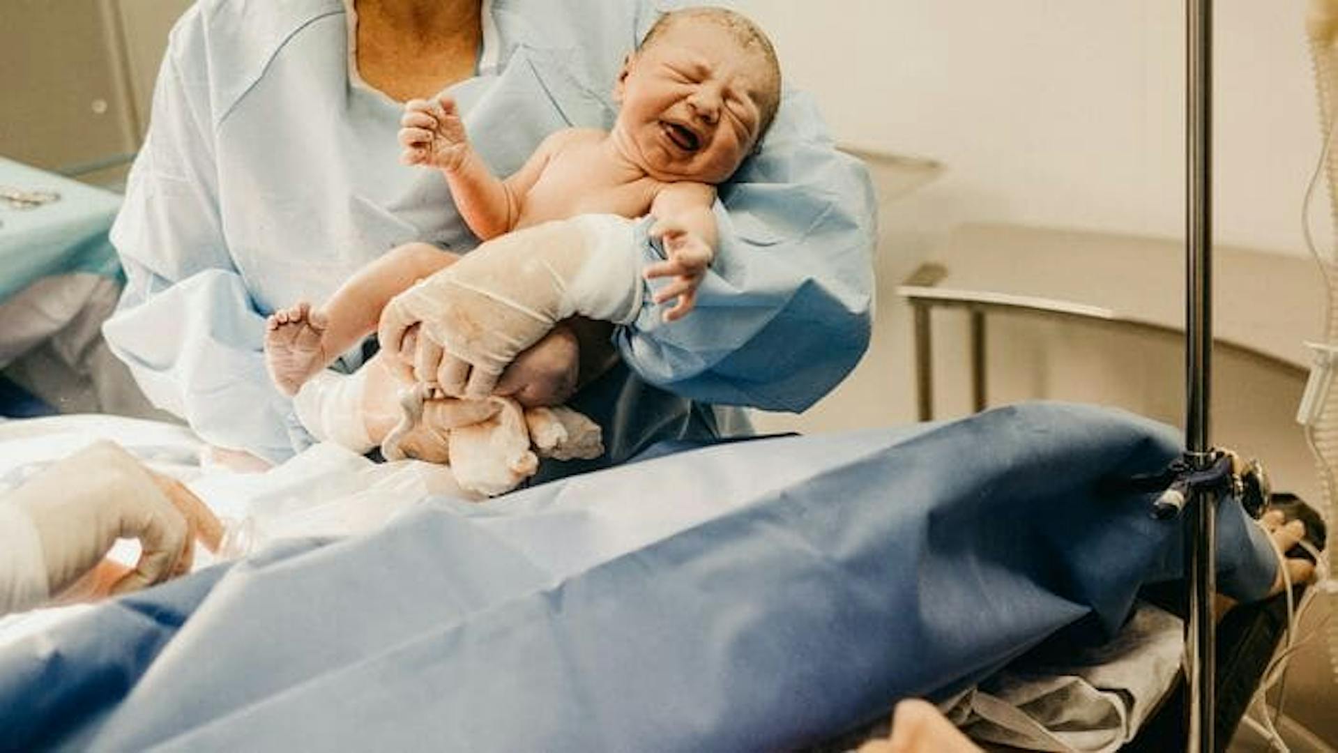 Médica segurando o bebê recém nascido pós parto