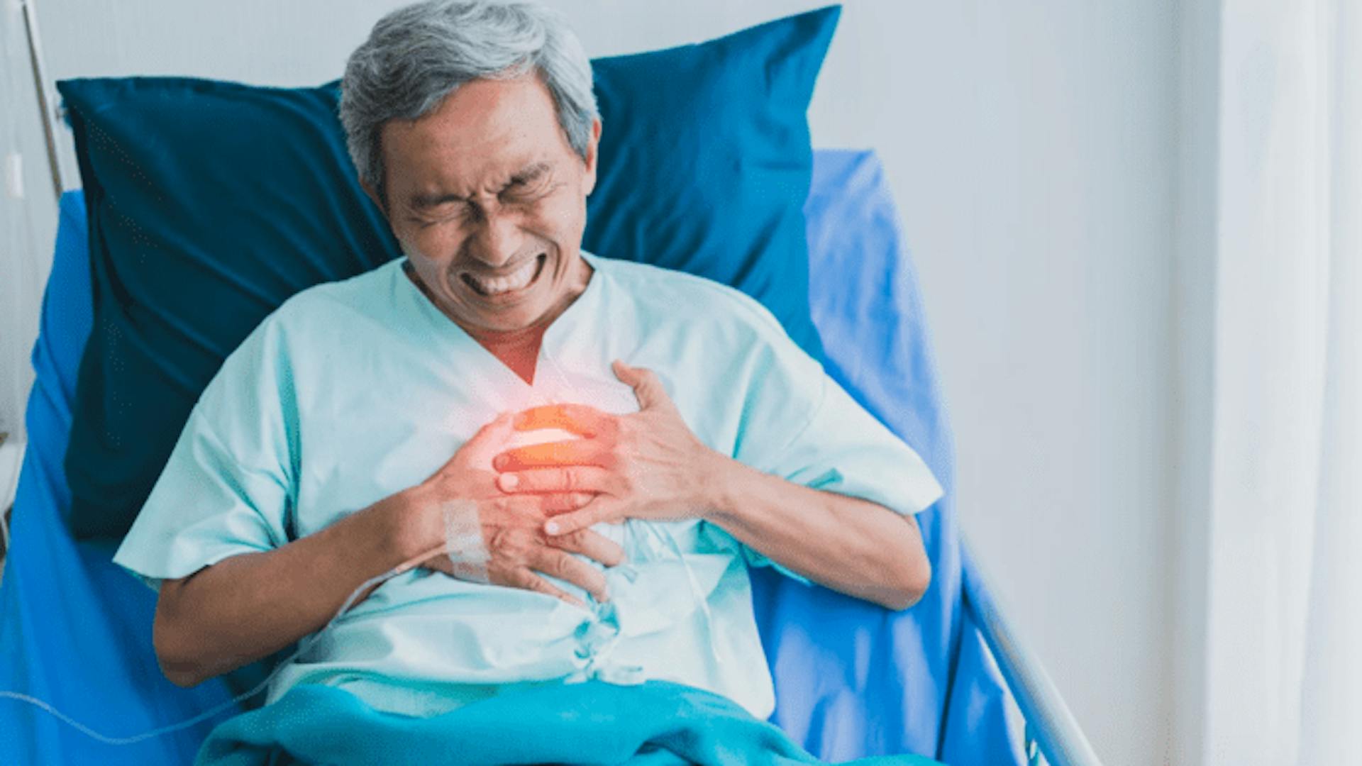homem asiático em cama hospitalar com dores no peito