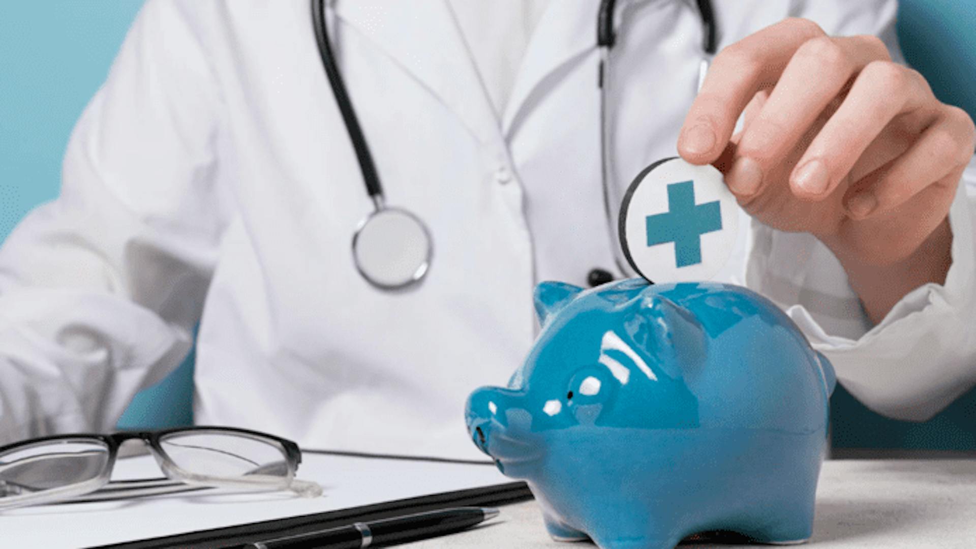 médico com jaleco branco e estetoscópio coloca moeda com símbolo da saúde em cofrinho azul