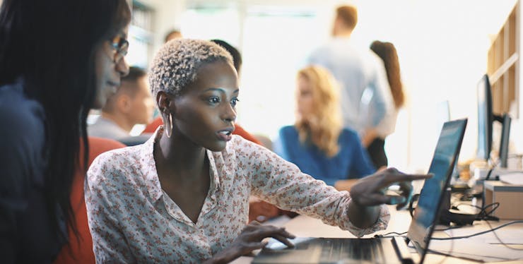 mulheres olhando conteúdo em notebook