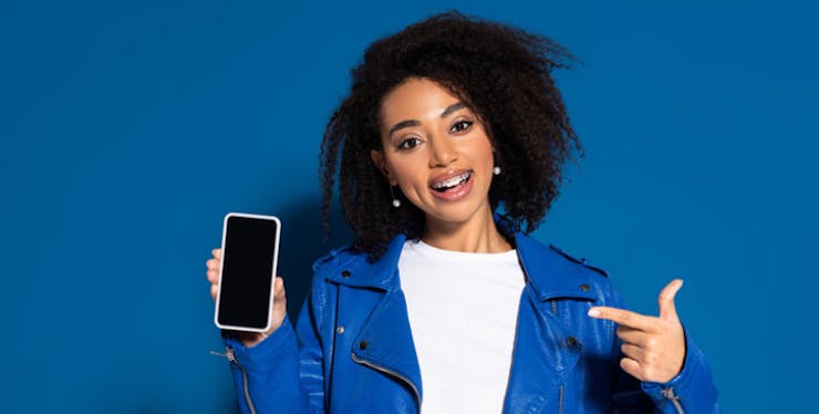 Mulher apontando para o celular na mão