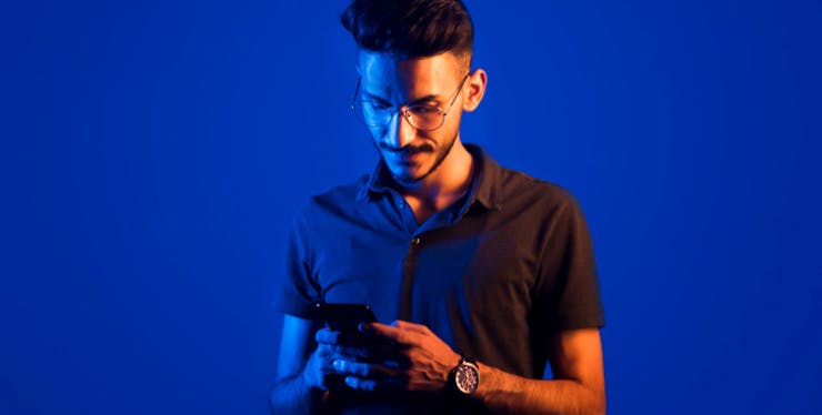 Homem olhando para celular nas mãos