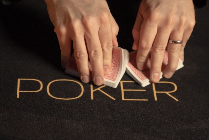 Hände, die Poker-Karten mischen