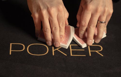 Karten in Händen auf Pokertisch