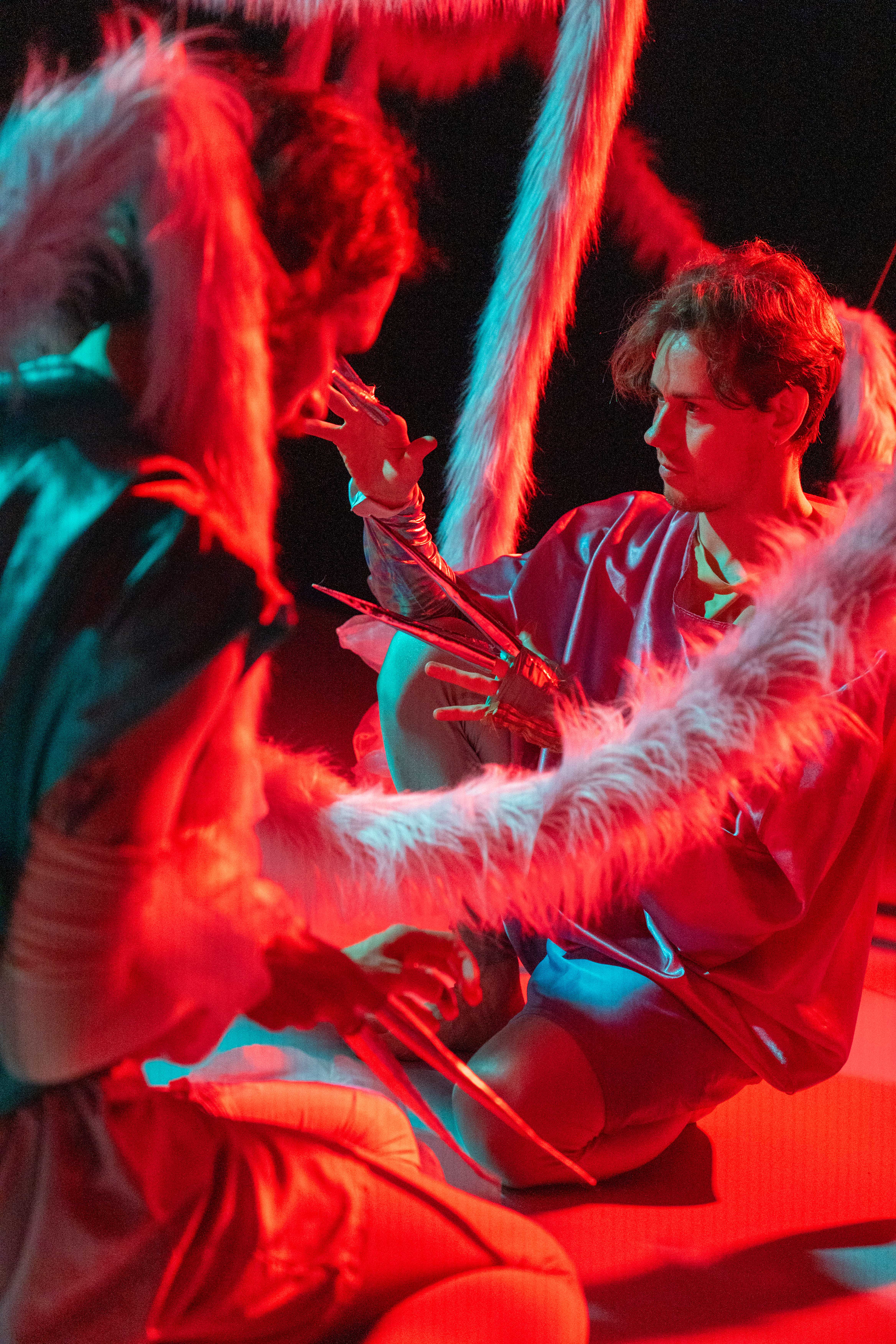 Two dancers in dark and red lit room 