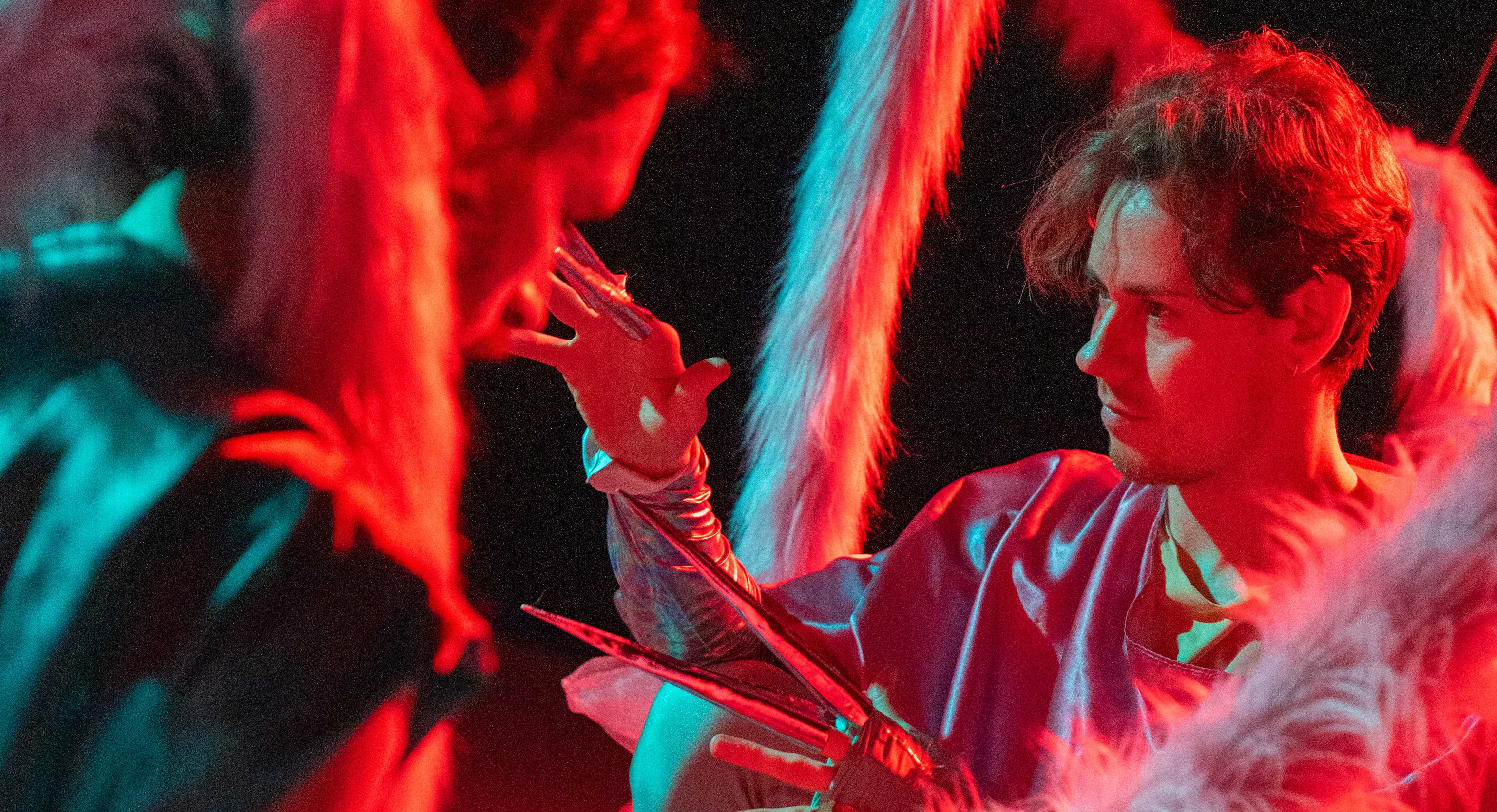 Two dancers in dark and red lit room