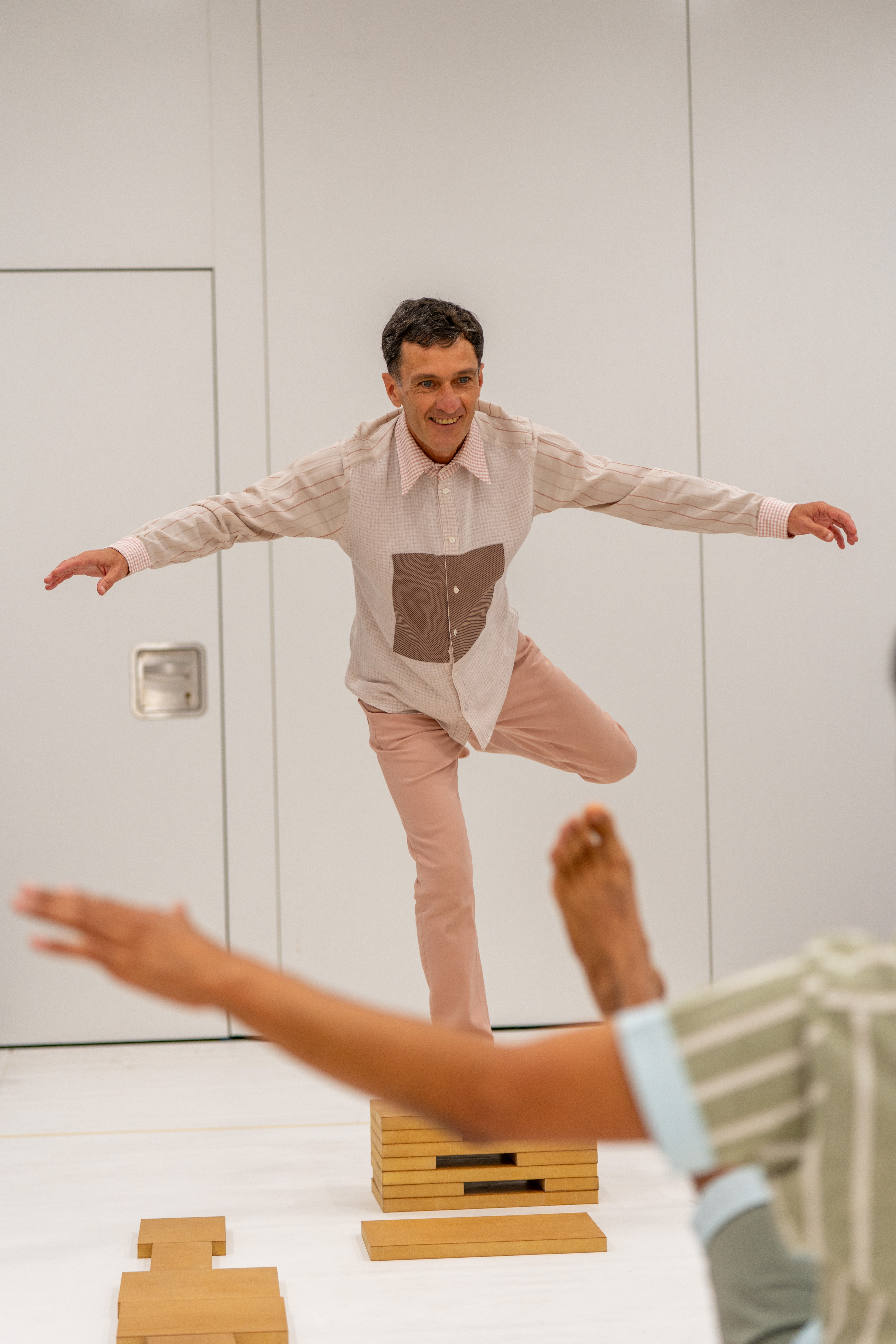 An artist balancing on a block with their hands up in the air 