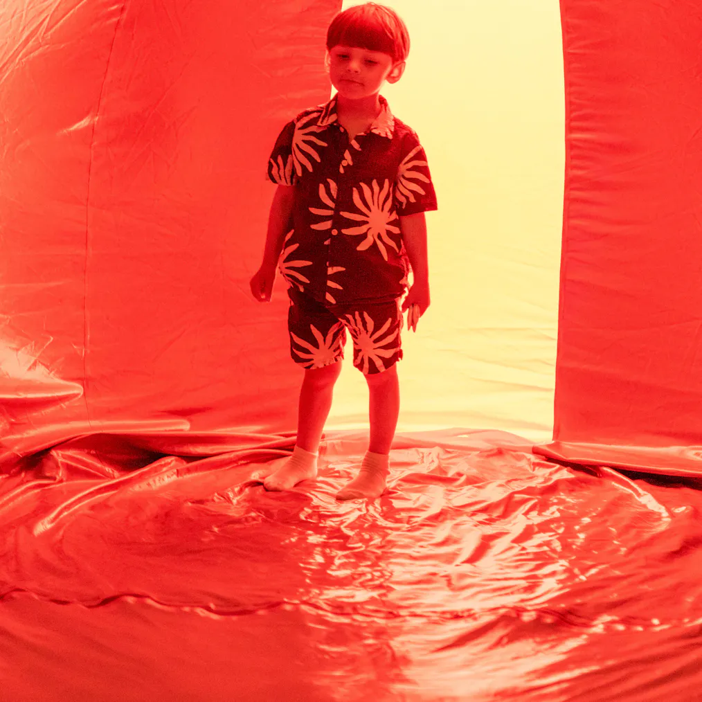 A young child stood in a red lit inflatable