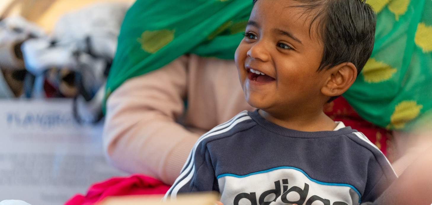 A baby smiling and looking away from the camera