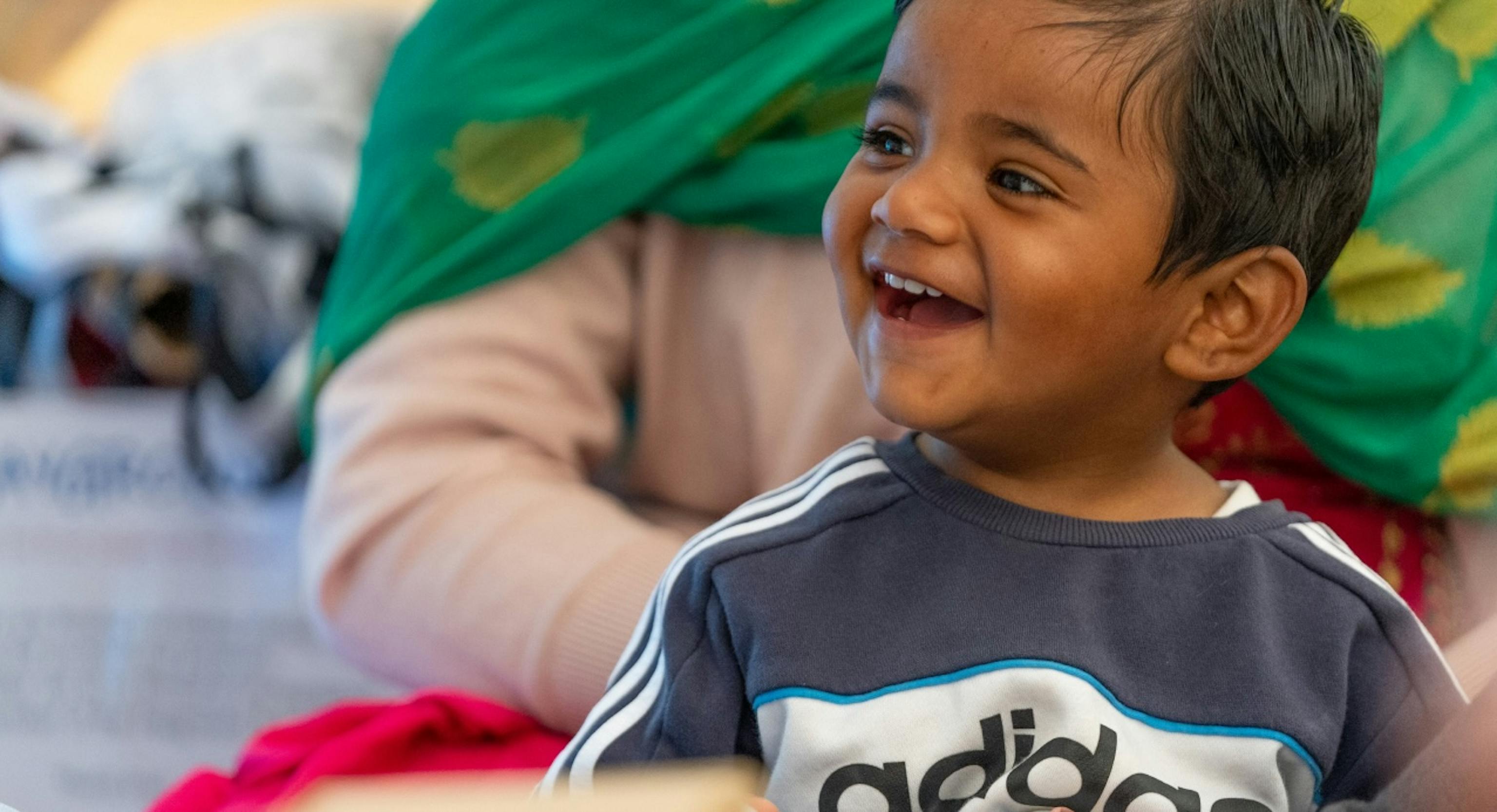 A baby smiling and looking away from the camera
