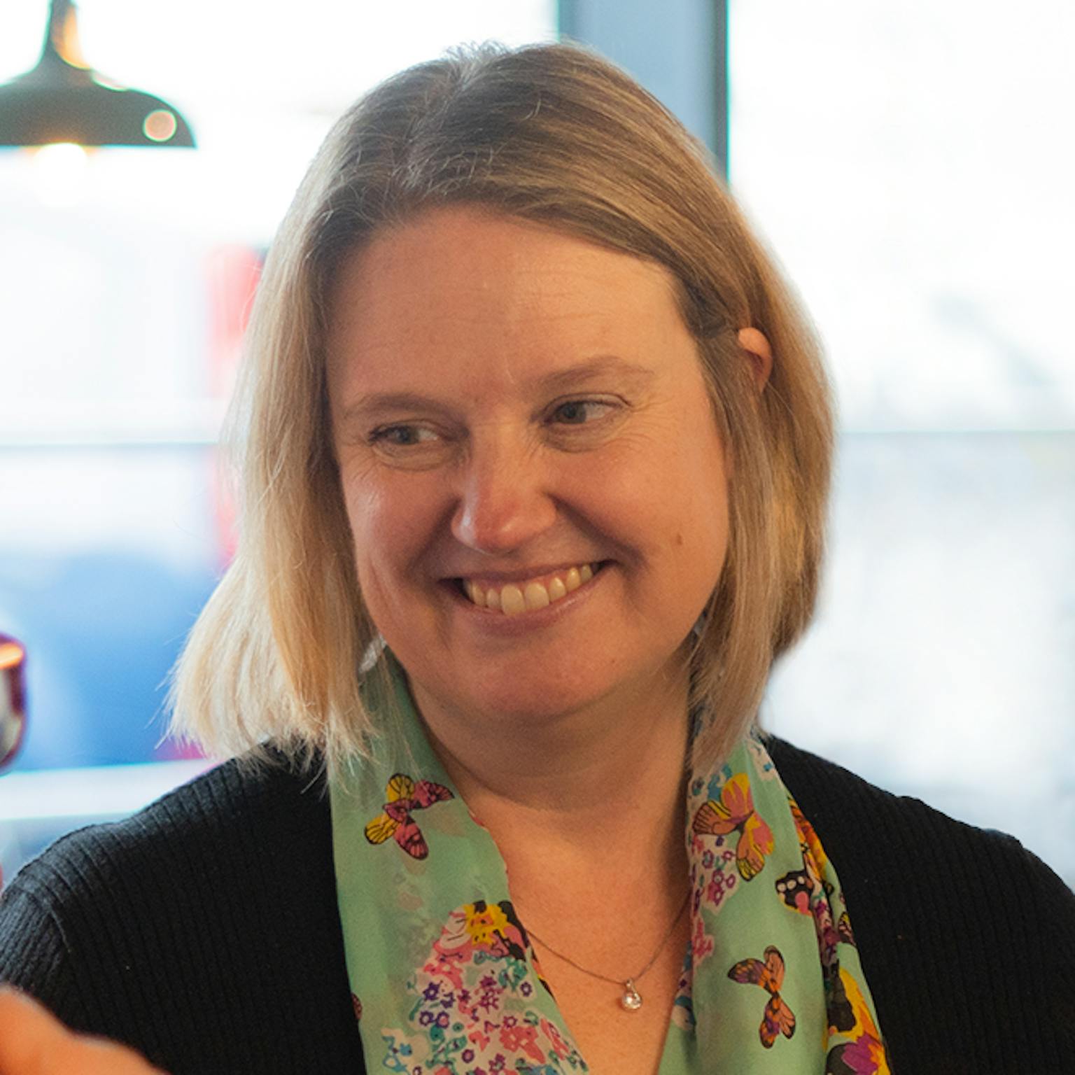 A person looking away from the camera and towards a colleague smiling