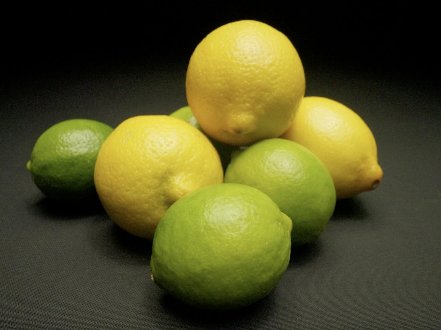 A selection of lemons and limes in a darkly lit room