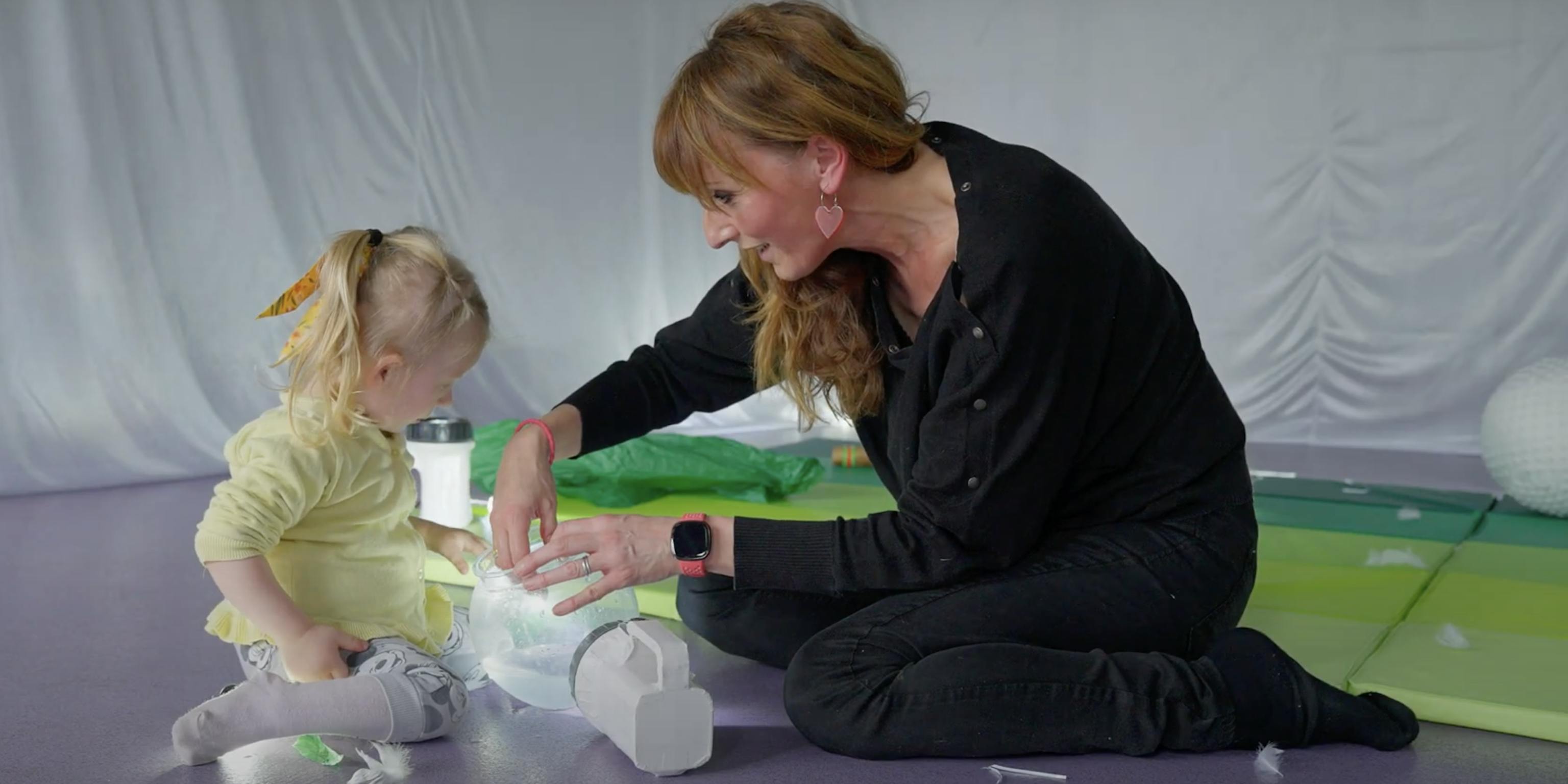 An artist and young young are exploring light during a session