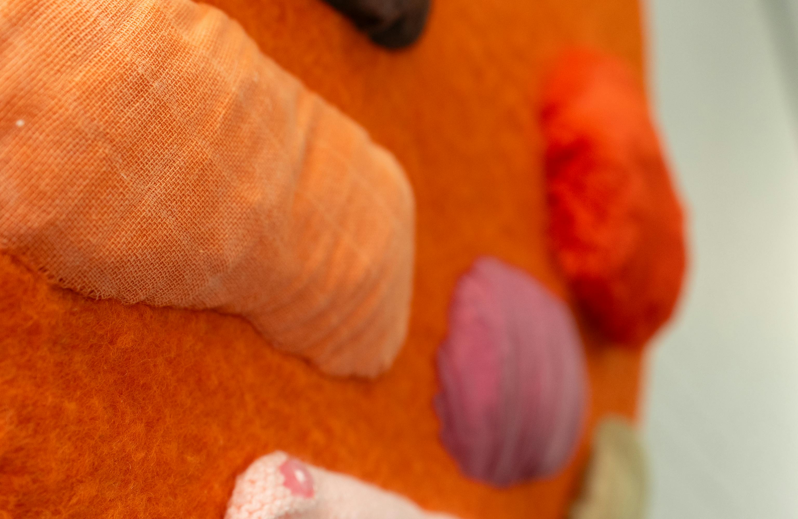 A close up of the Infant Feeding artwork shows a textured orange circle with different coloured shapes and textures added to it.