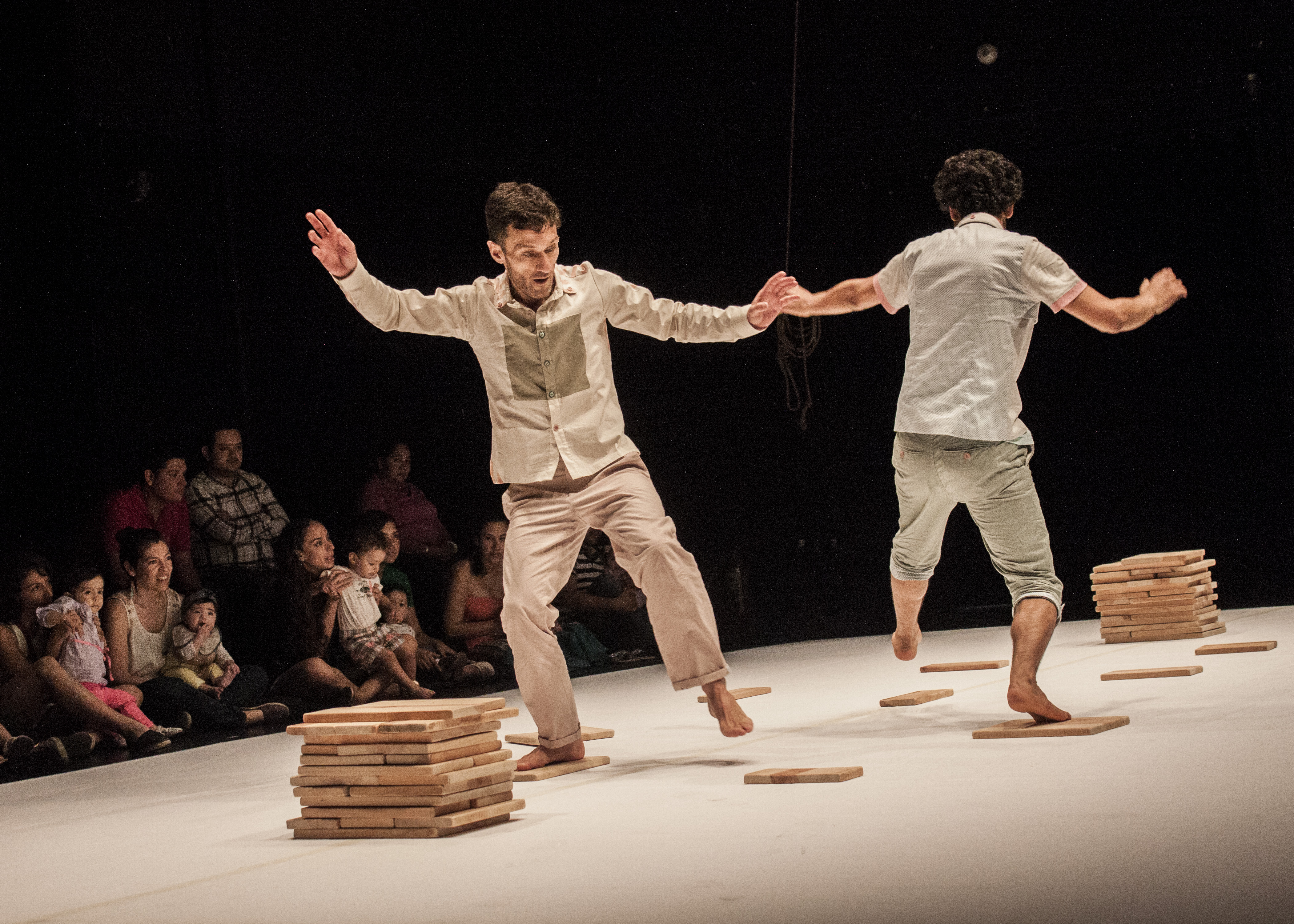 Two performers dancing on stage in front of an audience 